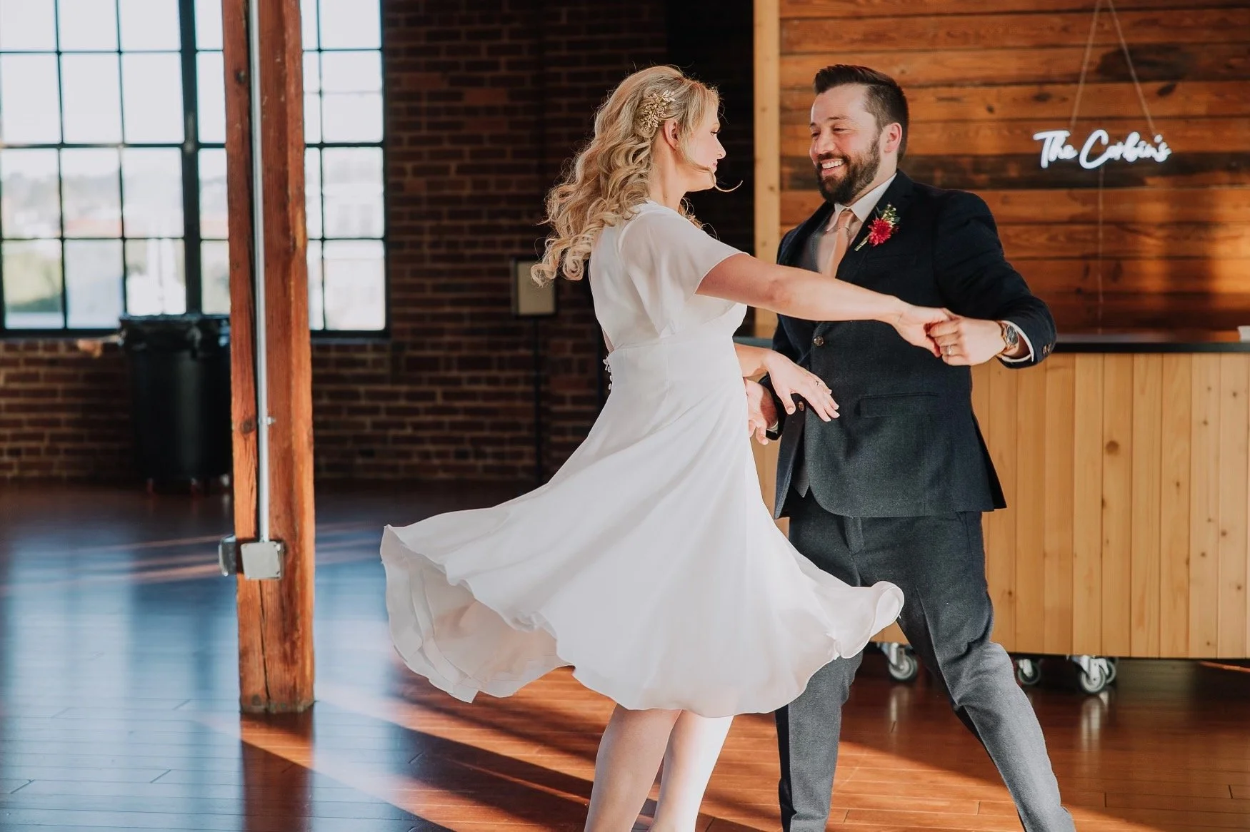 Kaley twirls gracefully during their wedding first dance with Jason, showcasing the elegance and skills learned at Emilie Cole Studios.