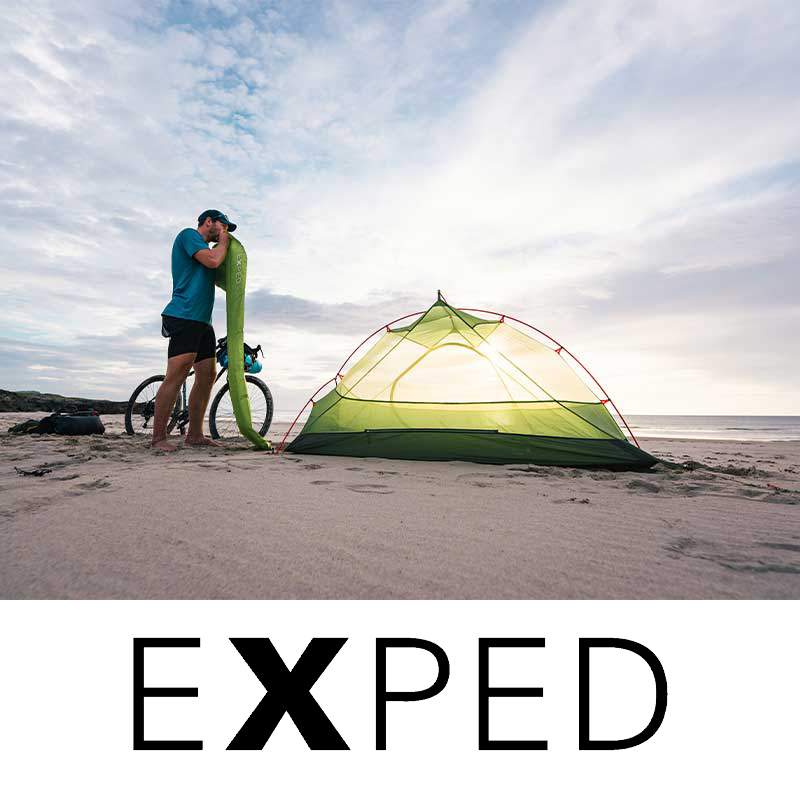 Beach camping set up with bike and EXPED logo beneath