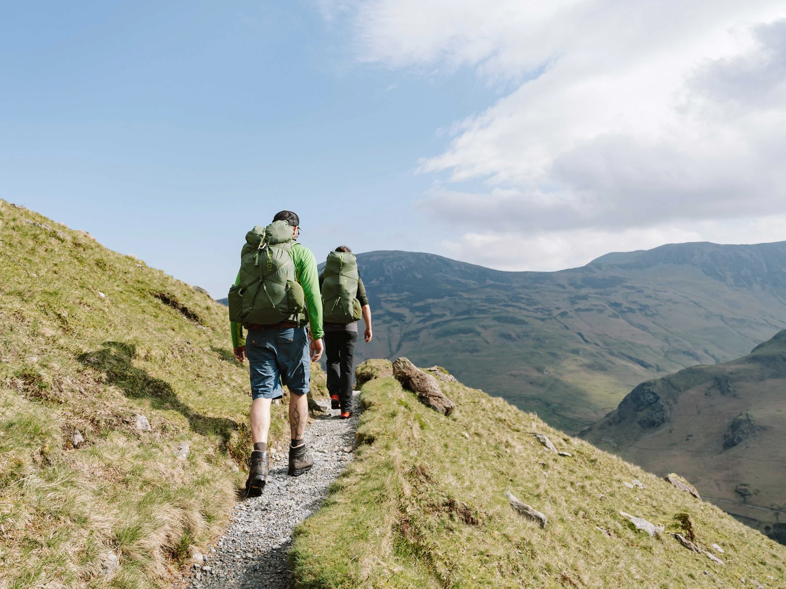 Two hikers with EXPED backpacks walking towards Buttermere