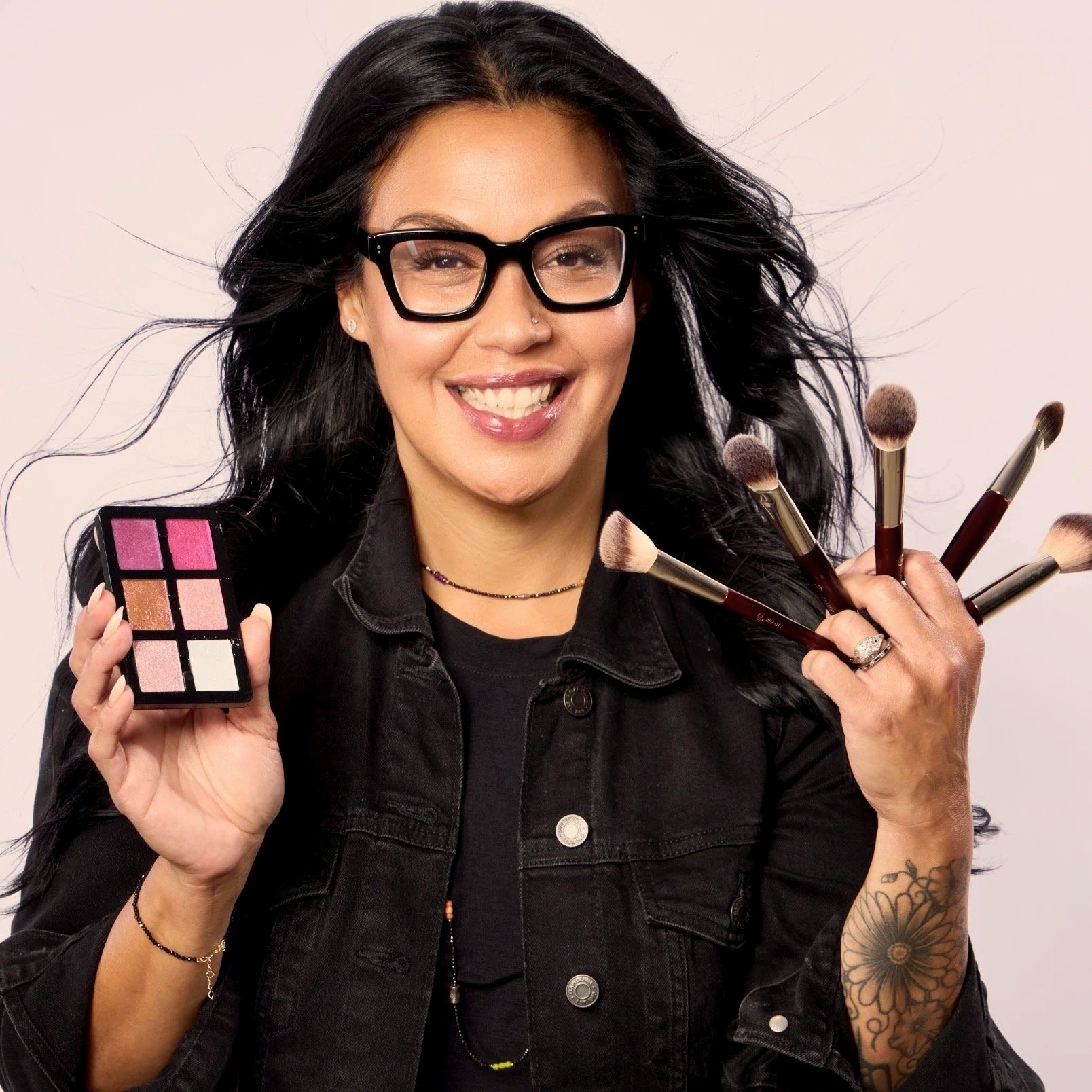 Modern building with wooden and white exterior in front of mountainous landscape with grassy field and shrubs.