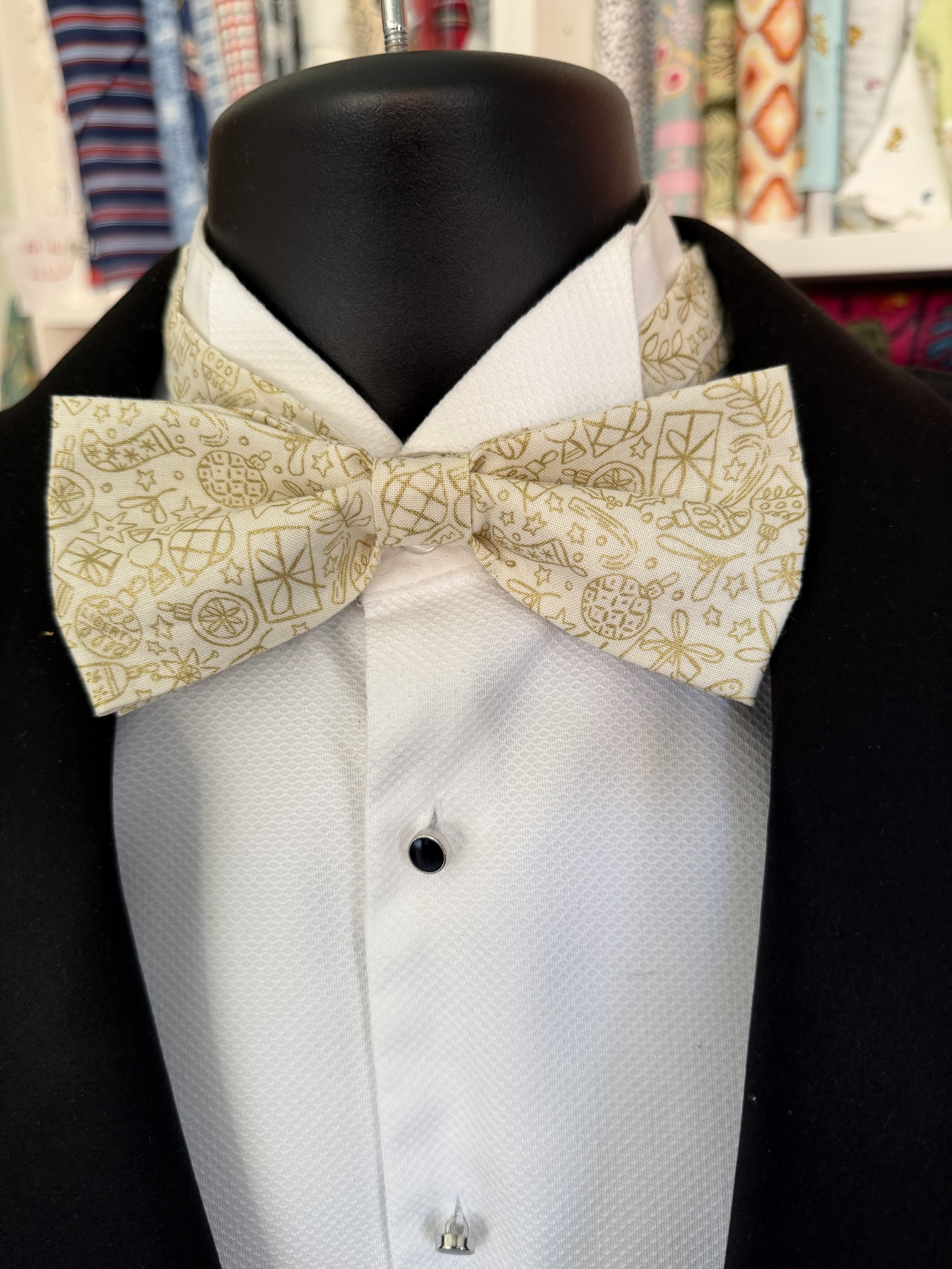 Handmade sewjackie bow tie in liberty fabric, featuring gold festive icons on cream fabric