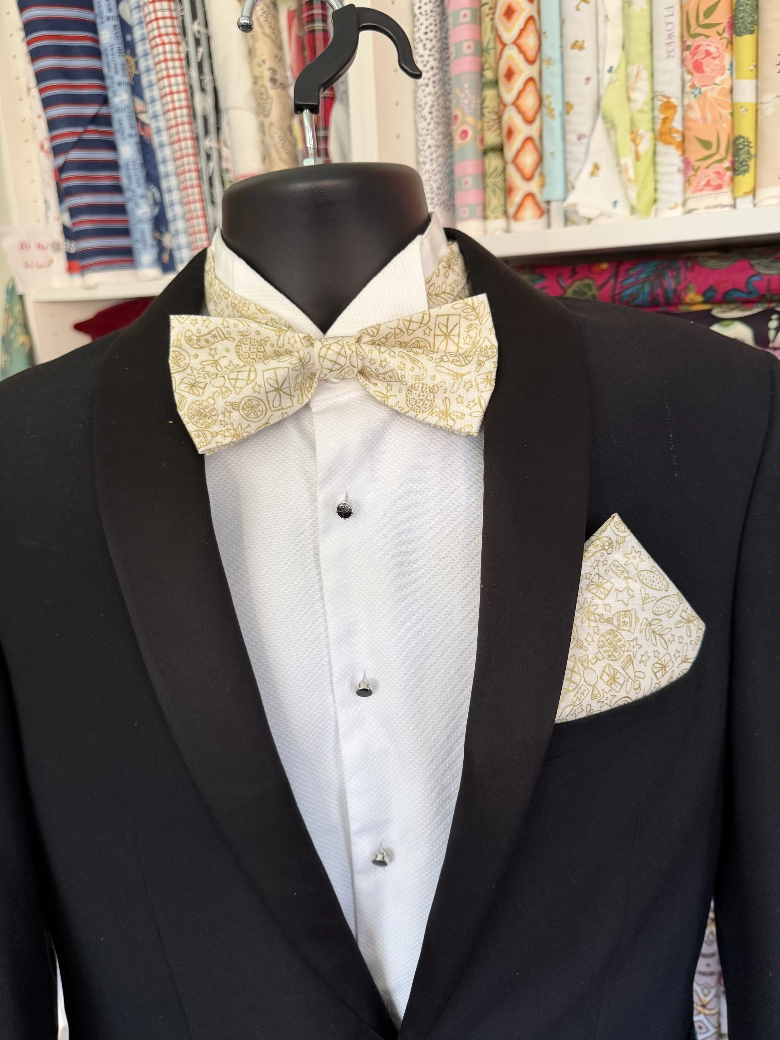 Handmade sewjackie bow tie and matching pocket square in liberty fabric, featuring gold festive icons on cream fabric