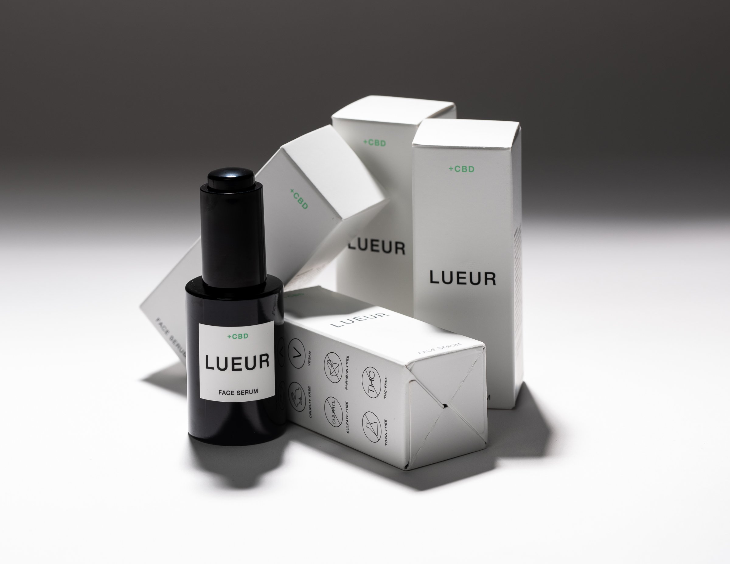 Lueur CBD face serum bottle and packaging on display against a neutral background.