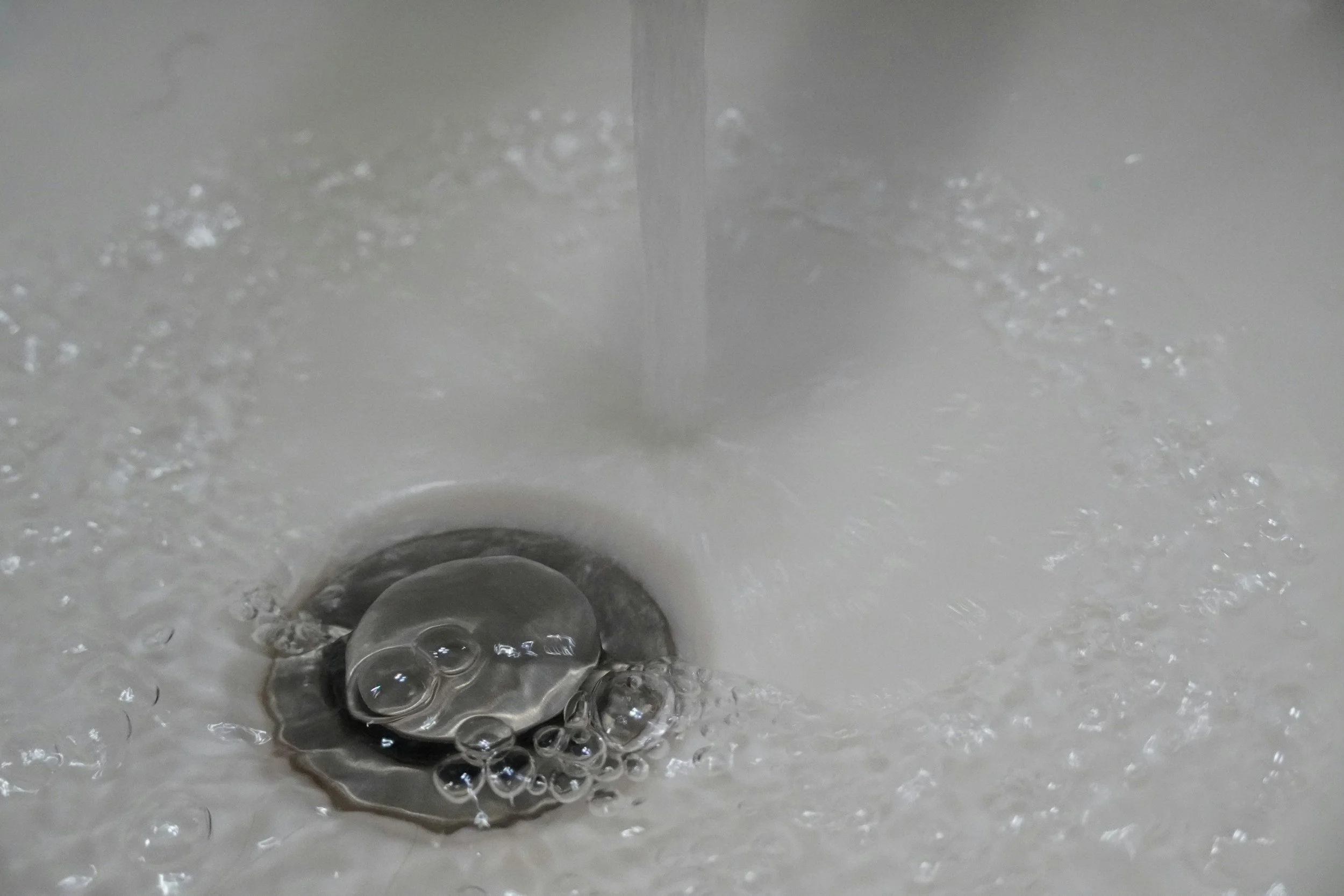 sink drain with water bubbling near drain