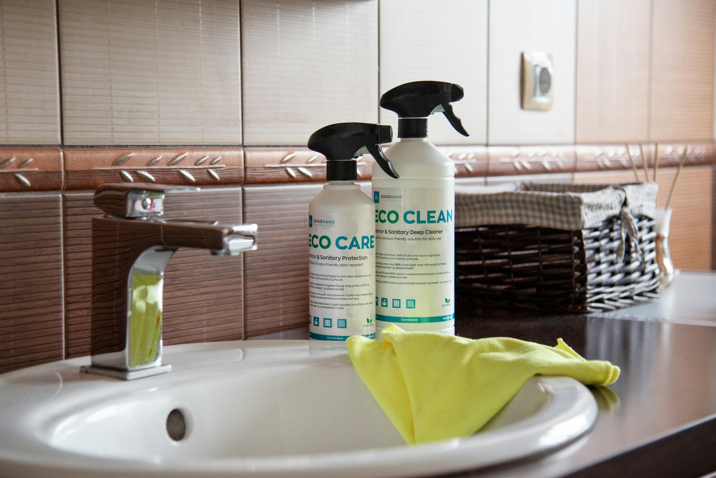 bathroom counter with images of cleaning products near sink and gloves resting on sink