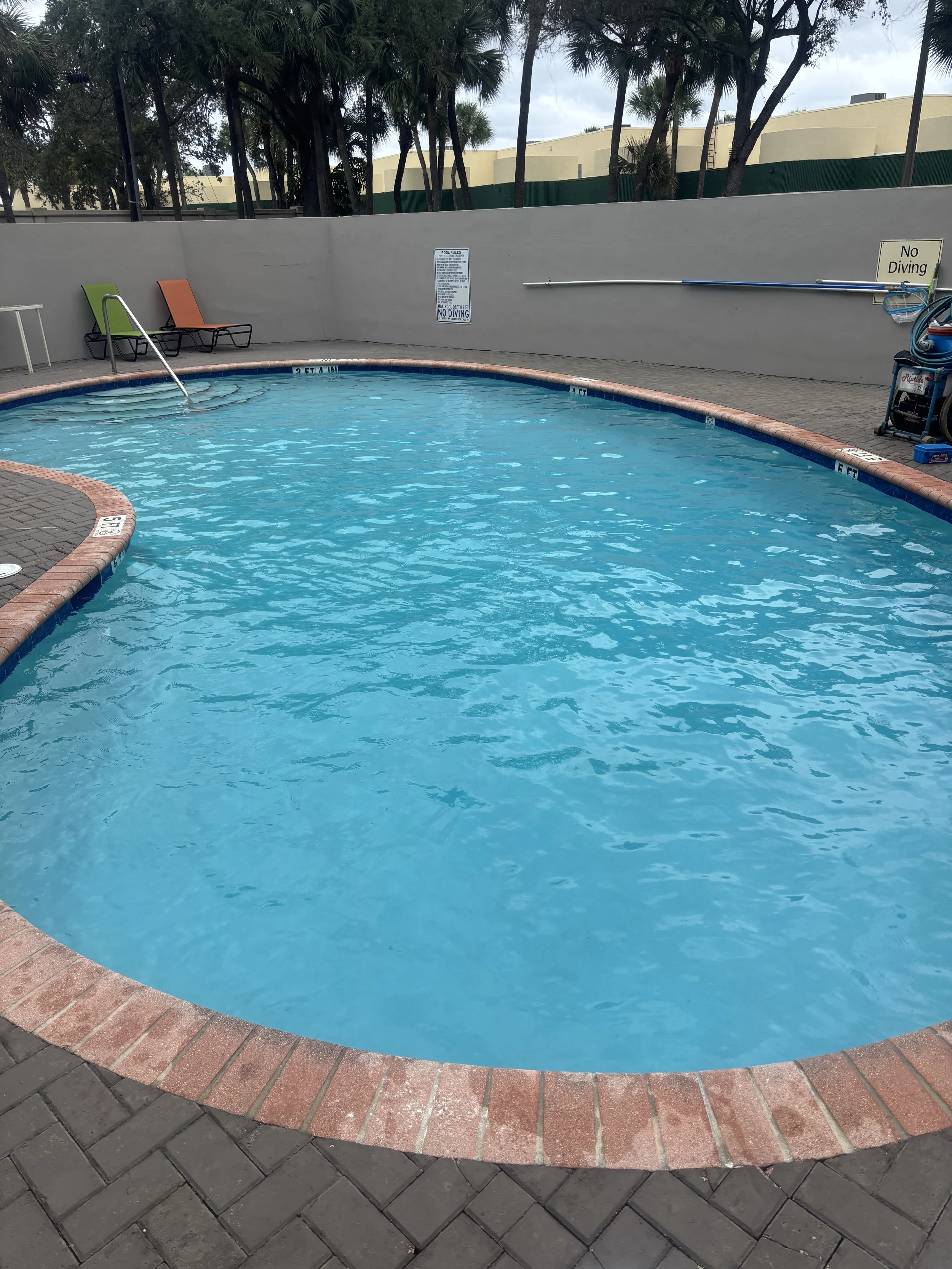 Commercial sky blue pool after pool maintenance and pool vacuuming