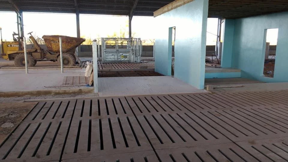 Construction site with wooden flooring, blue painted walls, and construction equipment.