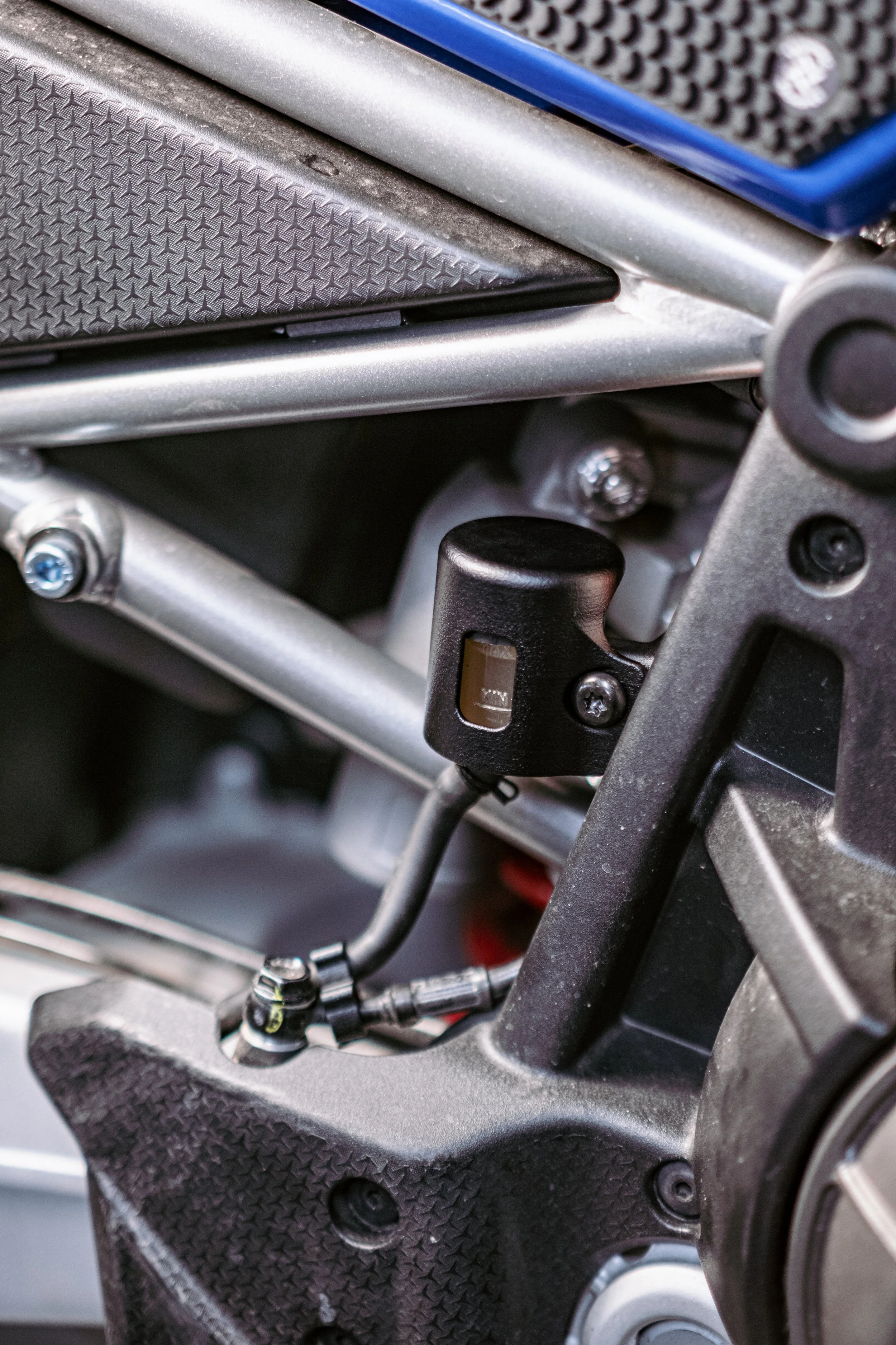 Close-up of a motorcycle's engine and clutch lever assembly with visible mechanical parts and textured surfaces.
