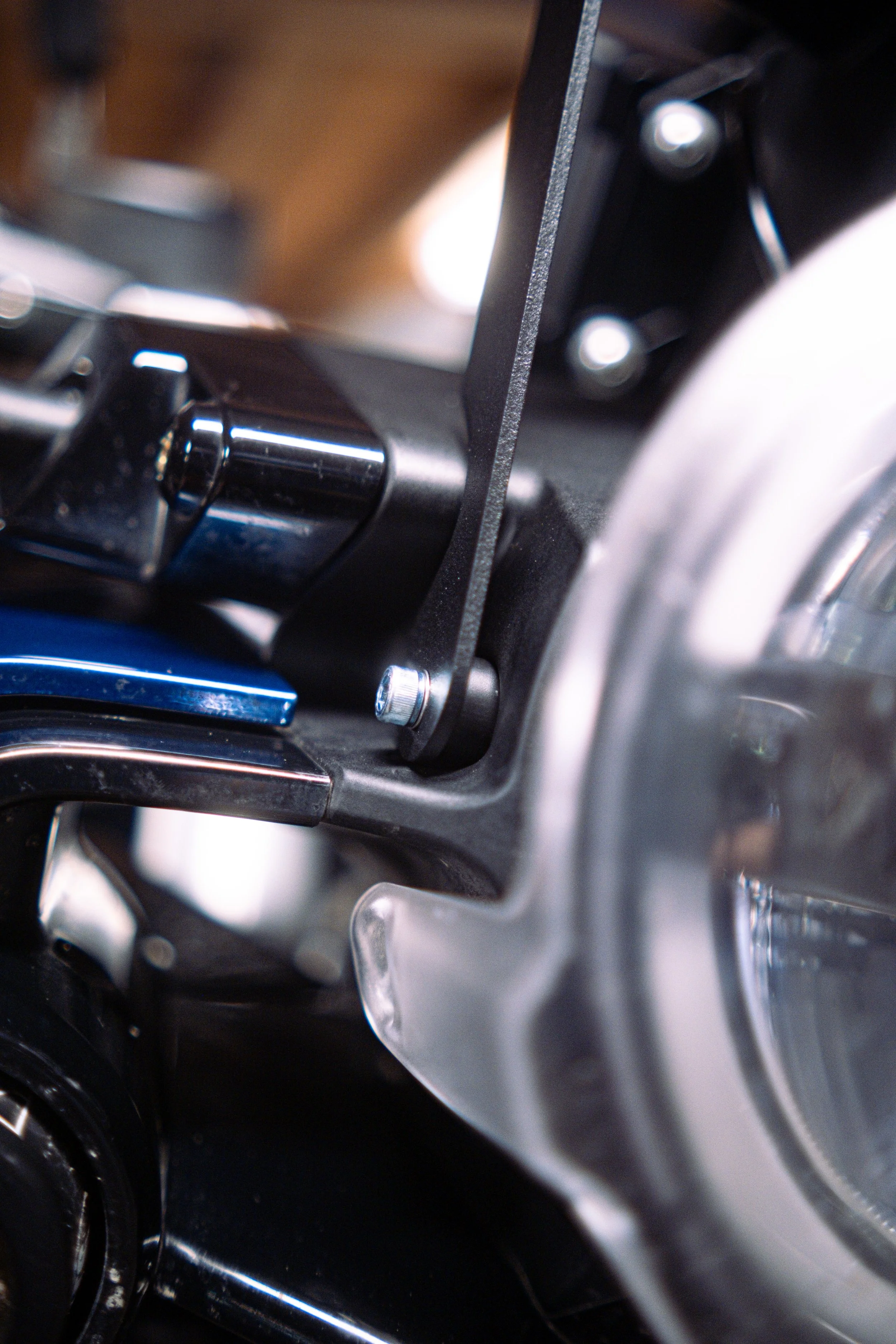 Close-up of a motorcycle engine with a black frame, metallic parts, and a visible screw.