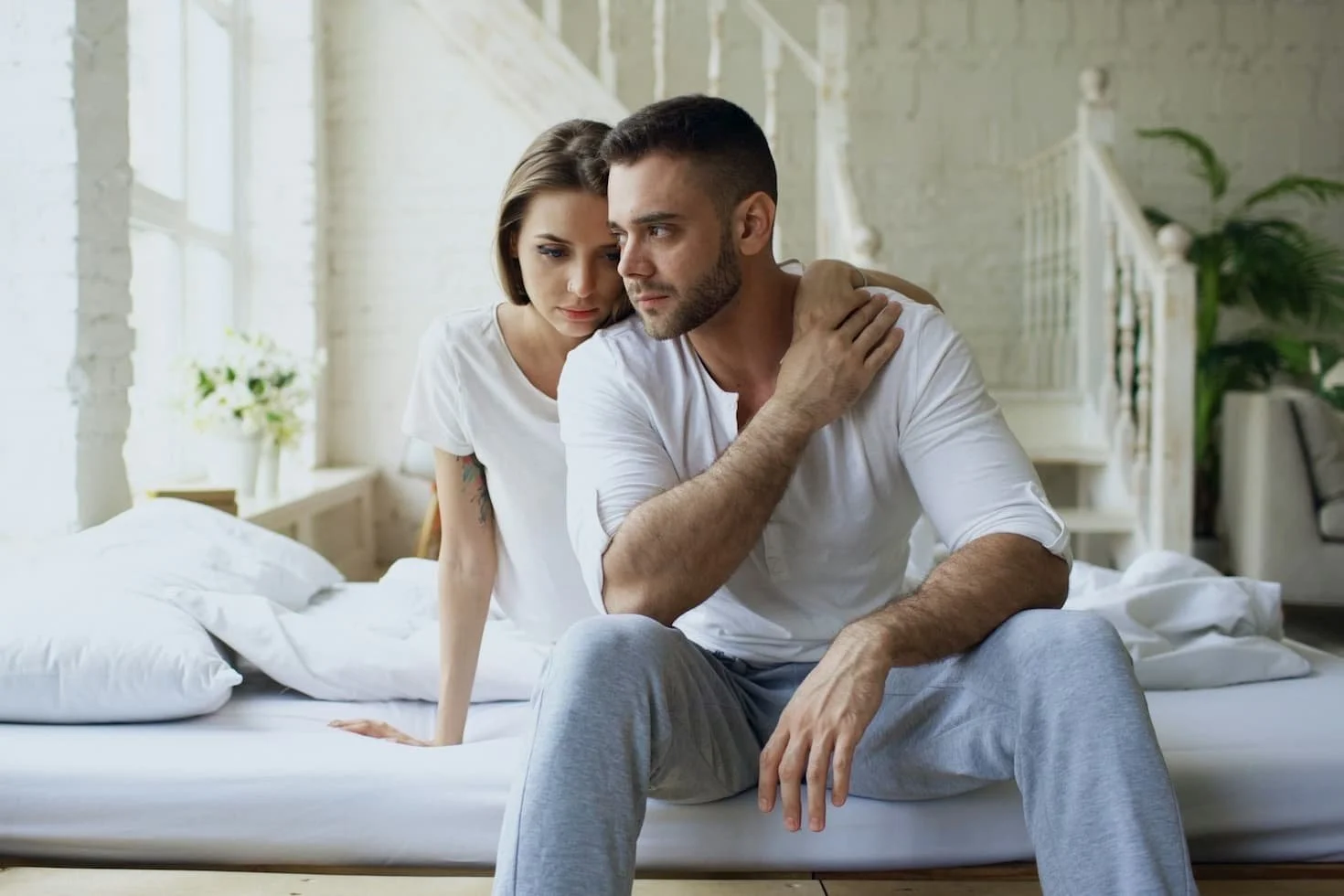 couple-sitting-on-a-bed-in-a-bright-room
