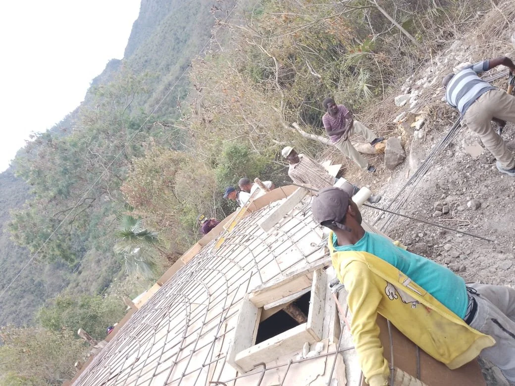 Construction workers building a sloped roof in a rural, mountainous area