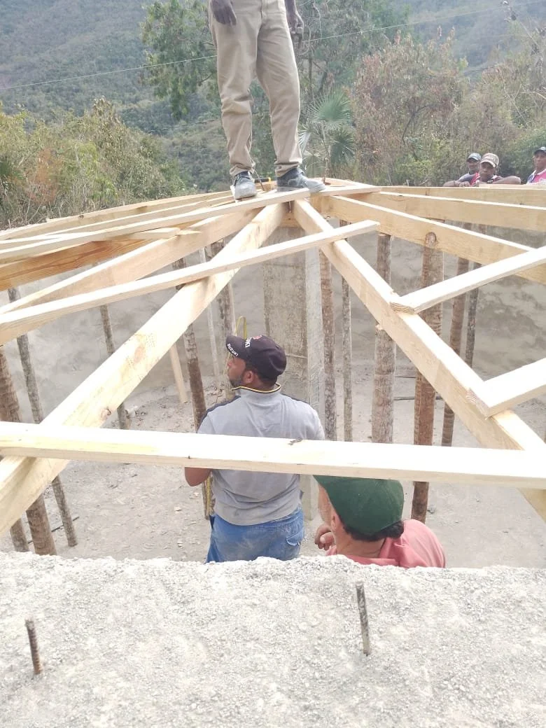 Construction workers on a wooden roof frame