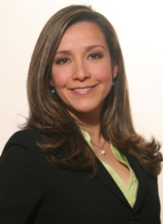 Professional woman with shoulder-length brown hair, wearing a black blazer and a light green blouse, smiling in a portrait photo.