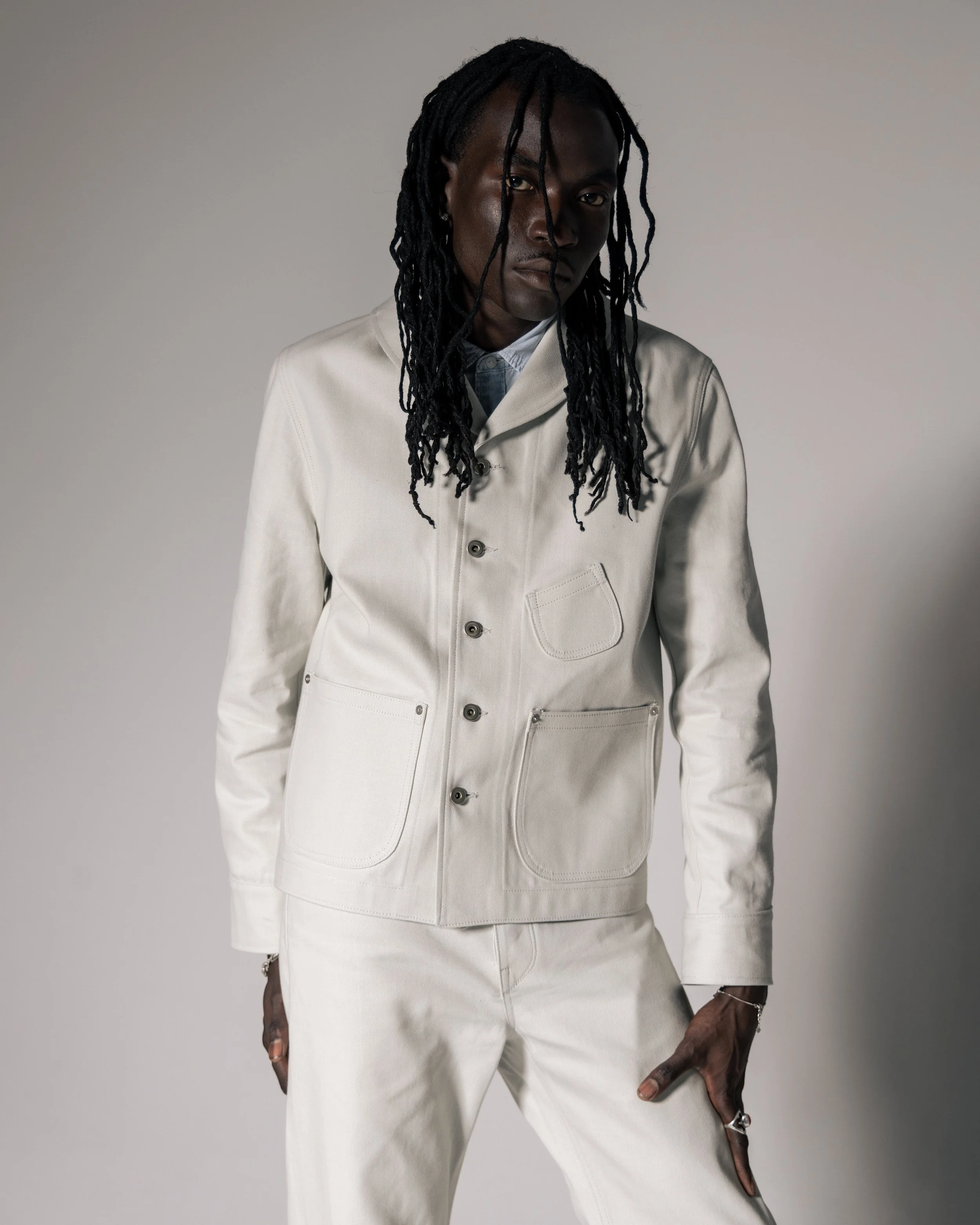 Ivory cream coloured denim suit with bag cinch shawl colar and large flared trousers.