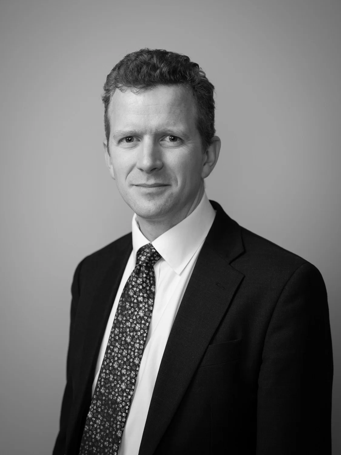 Corporate headshot of a man in a suit