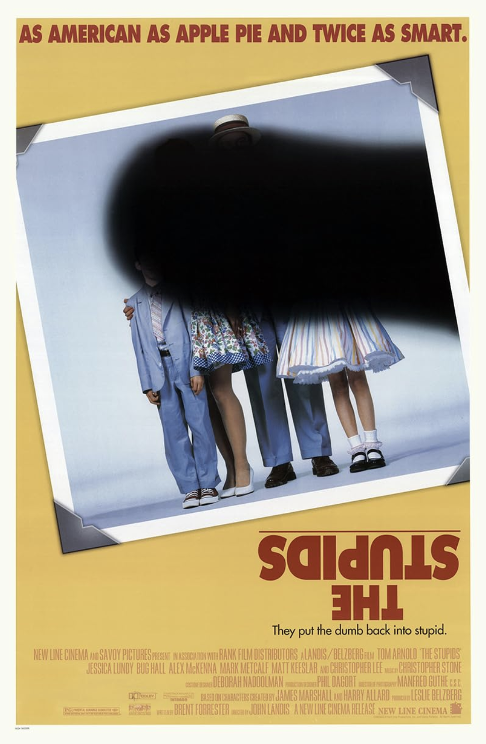 Movie poster for 'The Stupid's' featuring a partially obscured group of children dressed in colorful 1950s-style clothing, with the upper part of their faces hidden by a black ink blot.