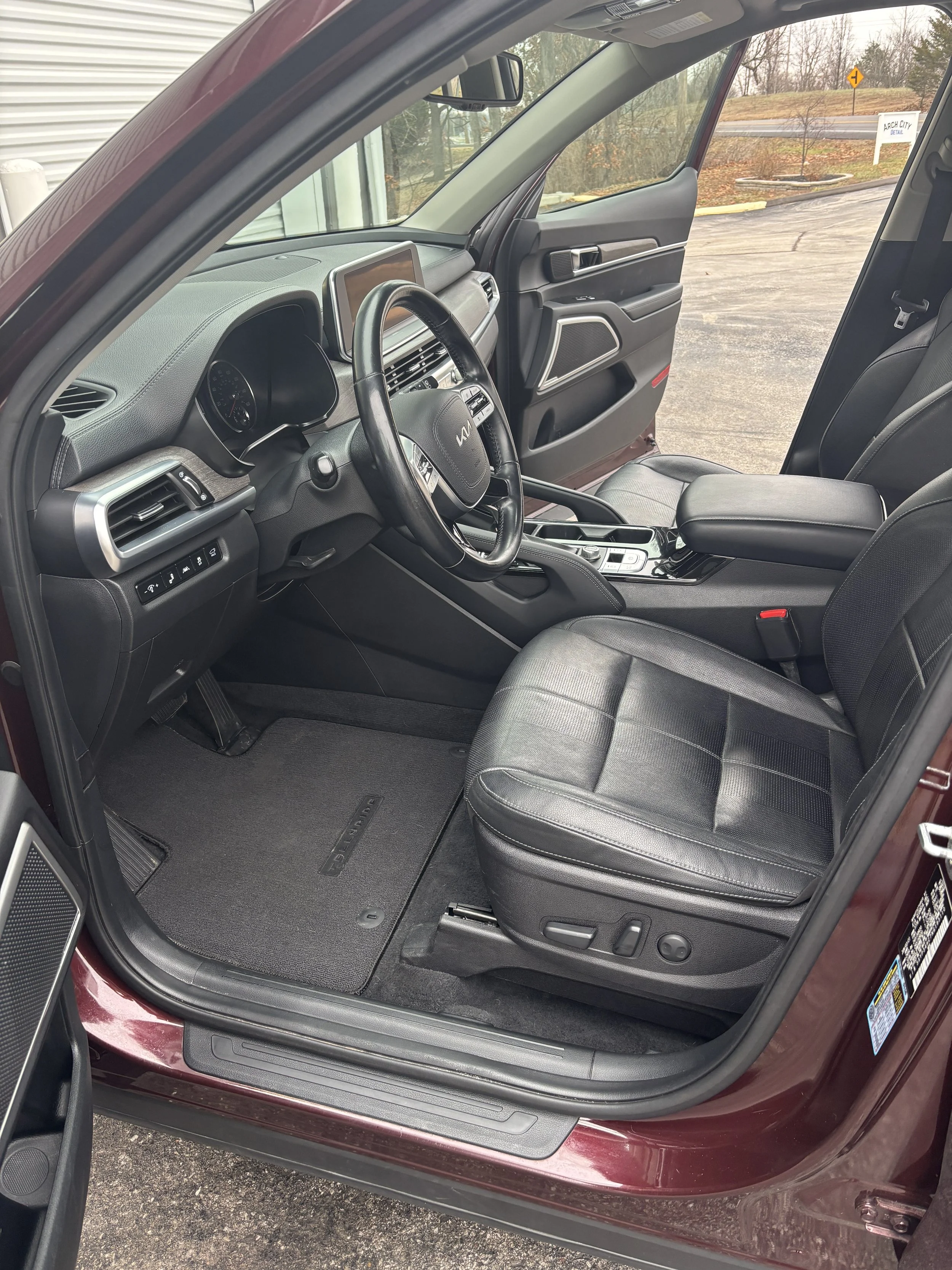 Interior view of a car showing the driver's seat, dashboard, steering wheel, and front passenger seat.