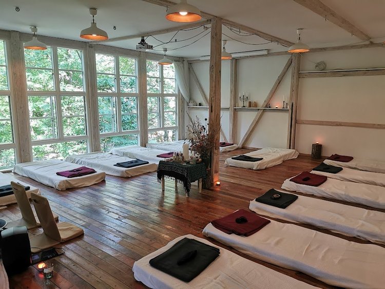Lyst retreatrum med madrasser og puder på trægulv