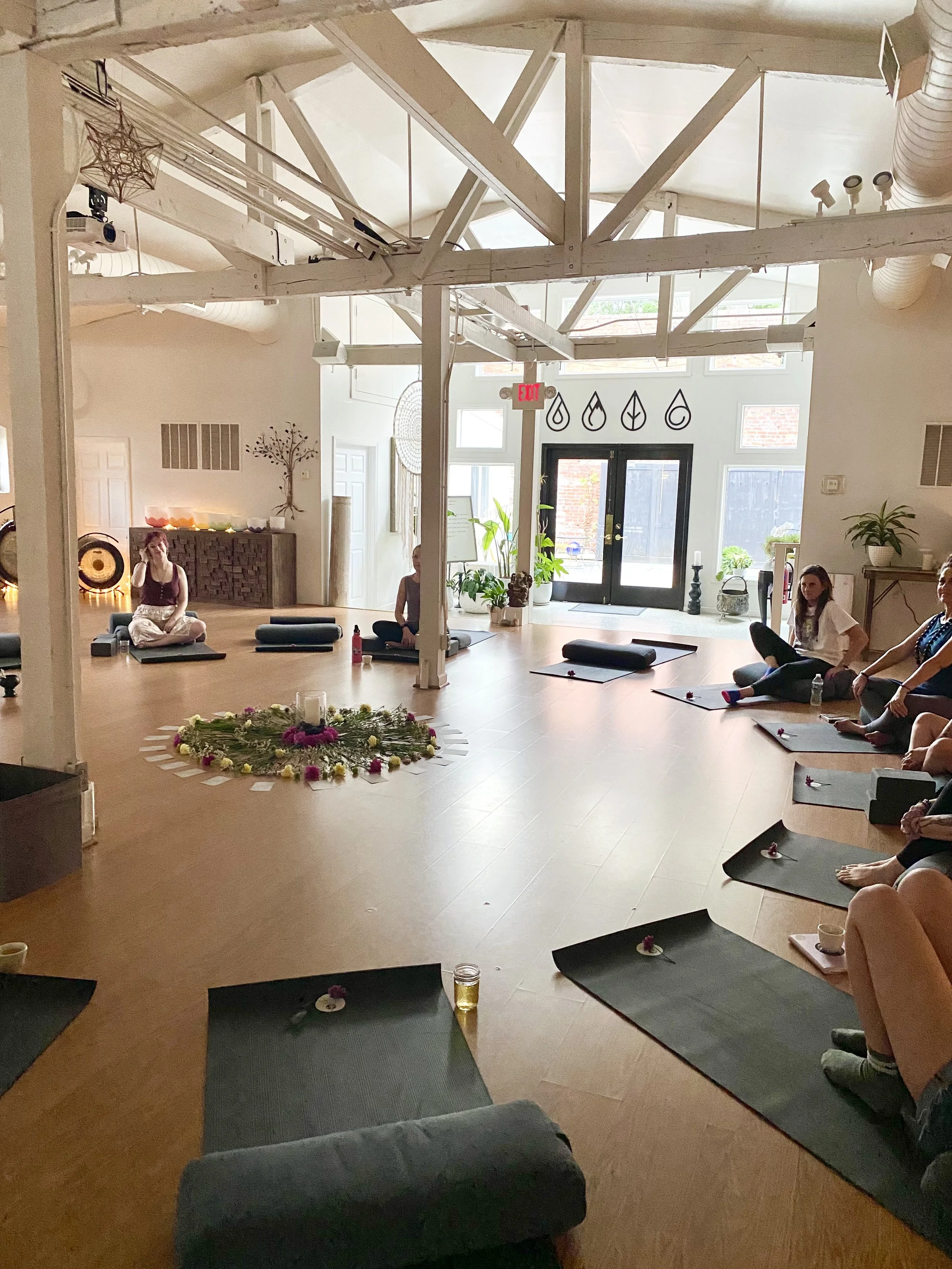 A large open room with yoga mats in a circle for women's circles and cacao ceremonies.