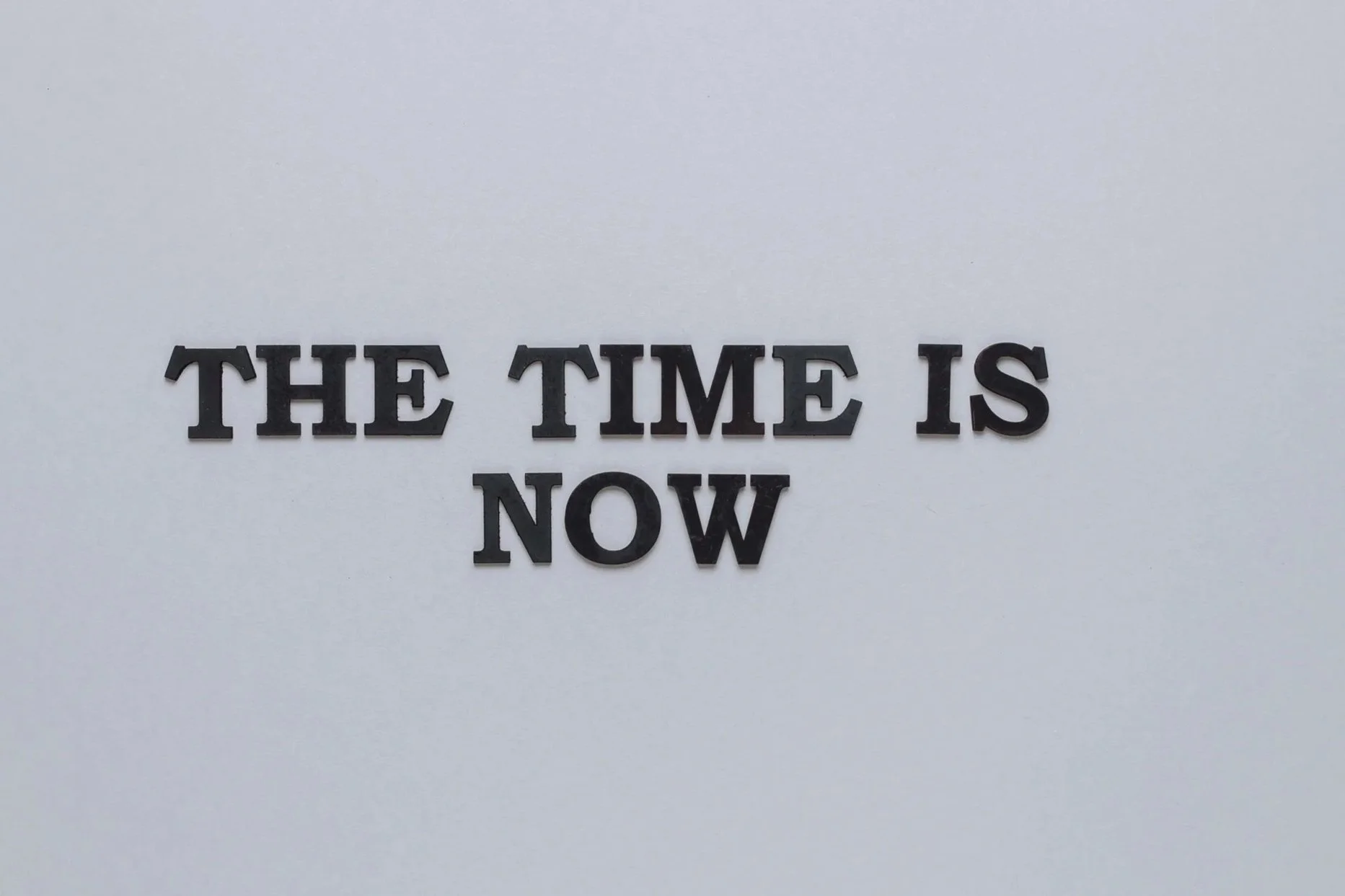 Text mit der Aufschrift „THE TIME IS NOW" auf weißem Hintergrund, als visuelles Signal für Dringlichkeit und zeitnahe Entscheidungsfindung.
