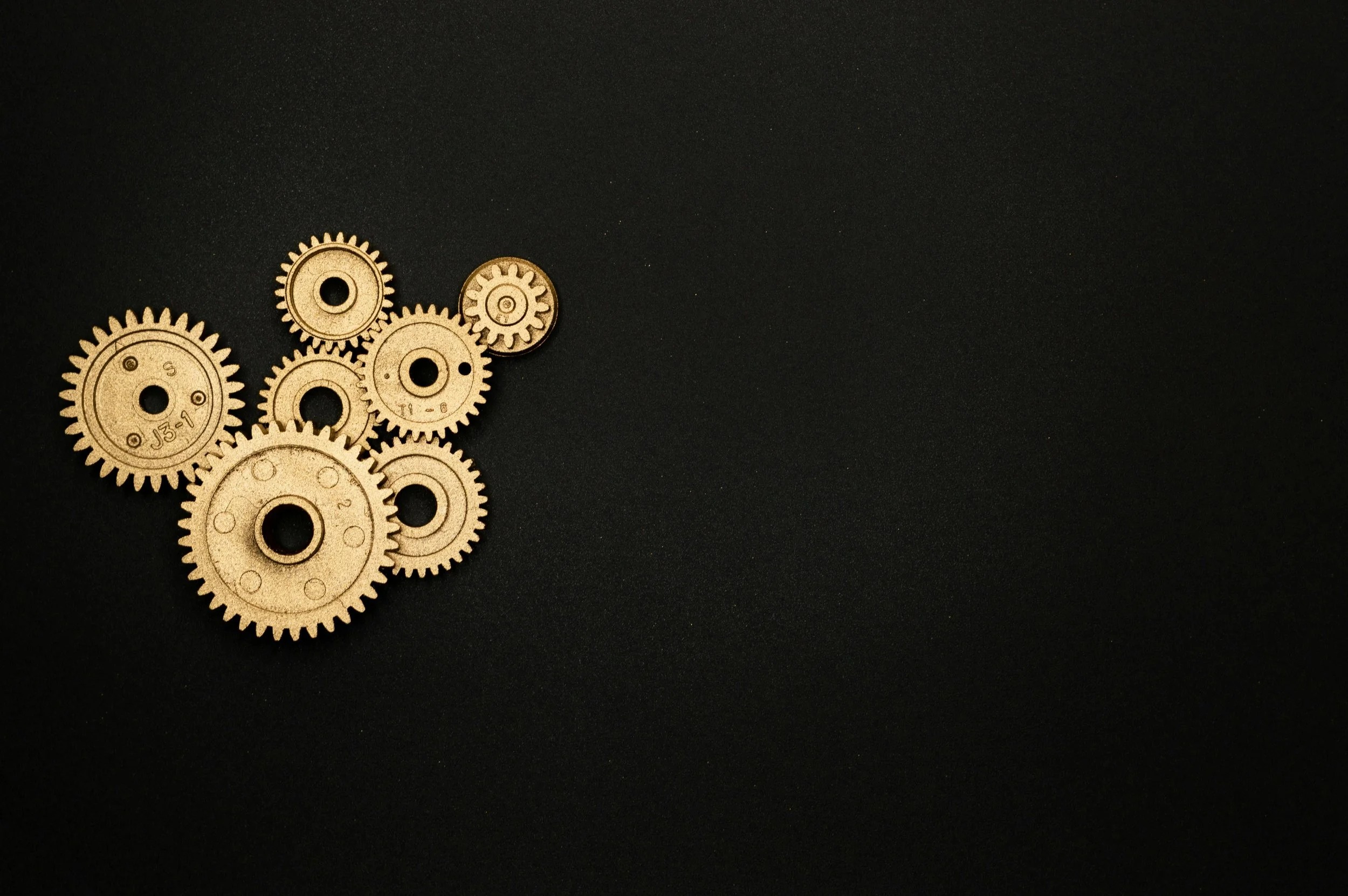 Interlocking brass gears symbolising decision systems and structural influences on thinking