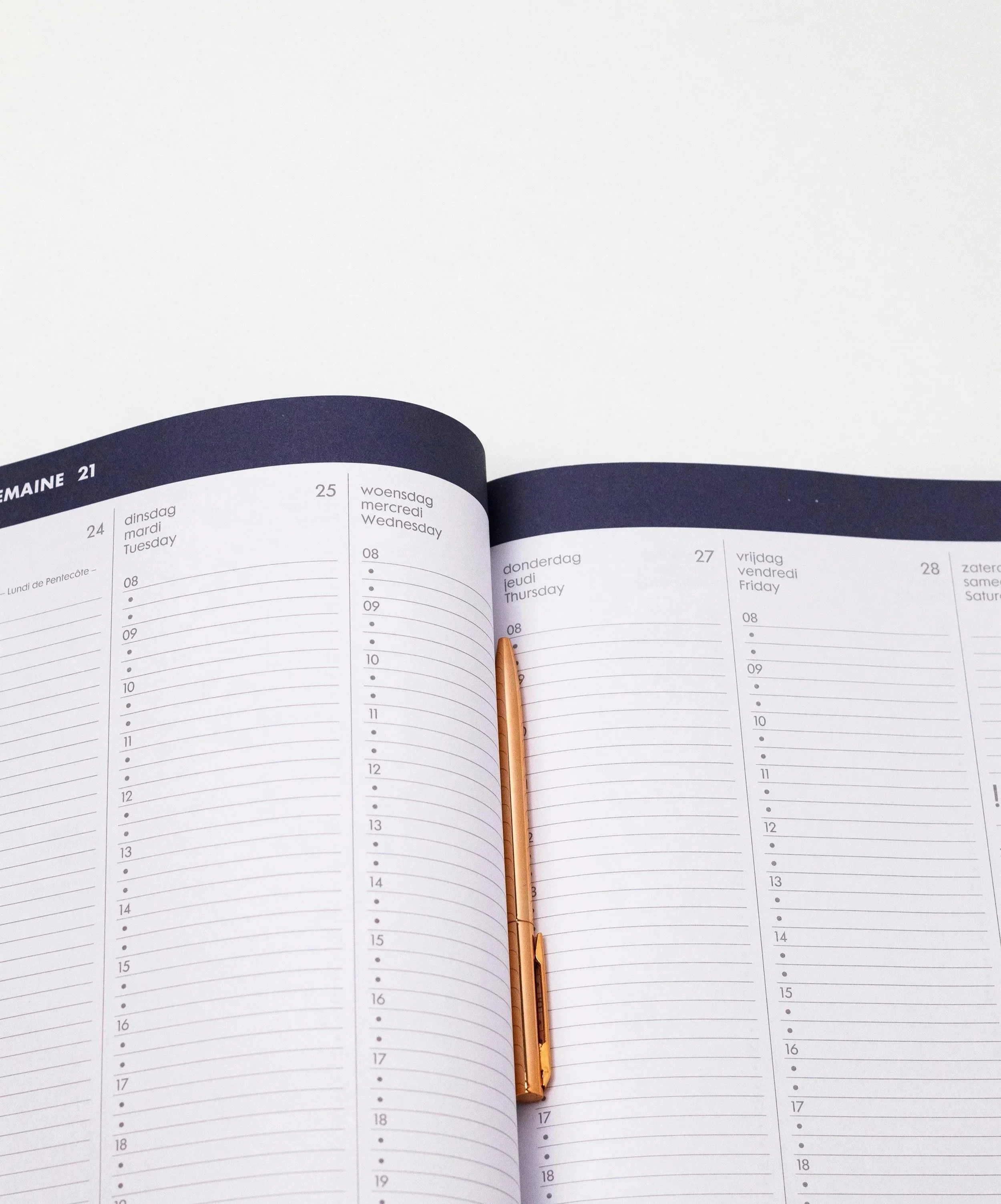 Aufgeschlagener Wochenkalender mit roségoldenem Stift, als Symbol für Terminvereinbarung und Kontaktaufnahme.