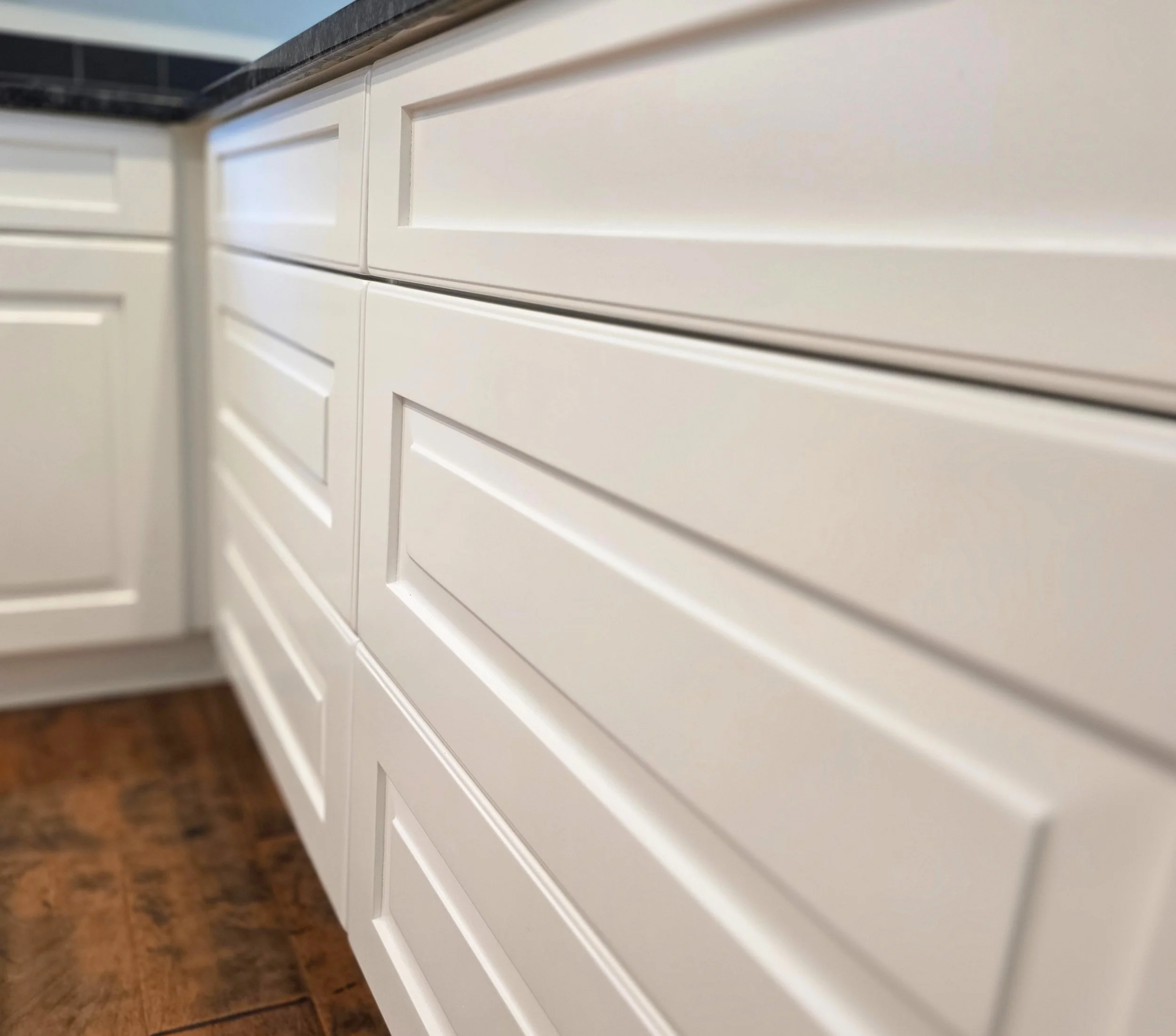 Close-up of a spray-finished kitchen cabinet door showing a smooth factory-like finish, Canmore AB