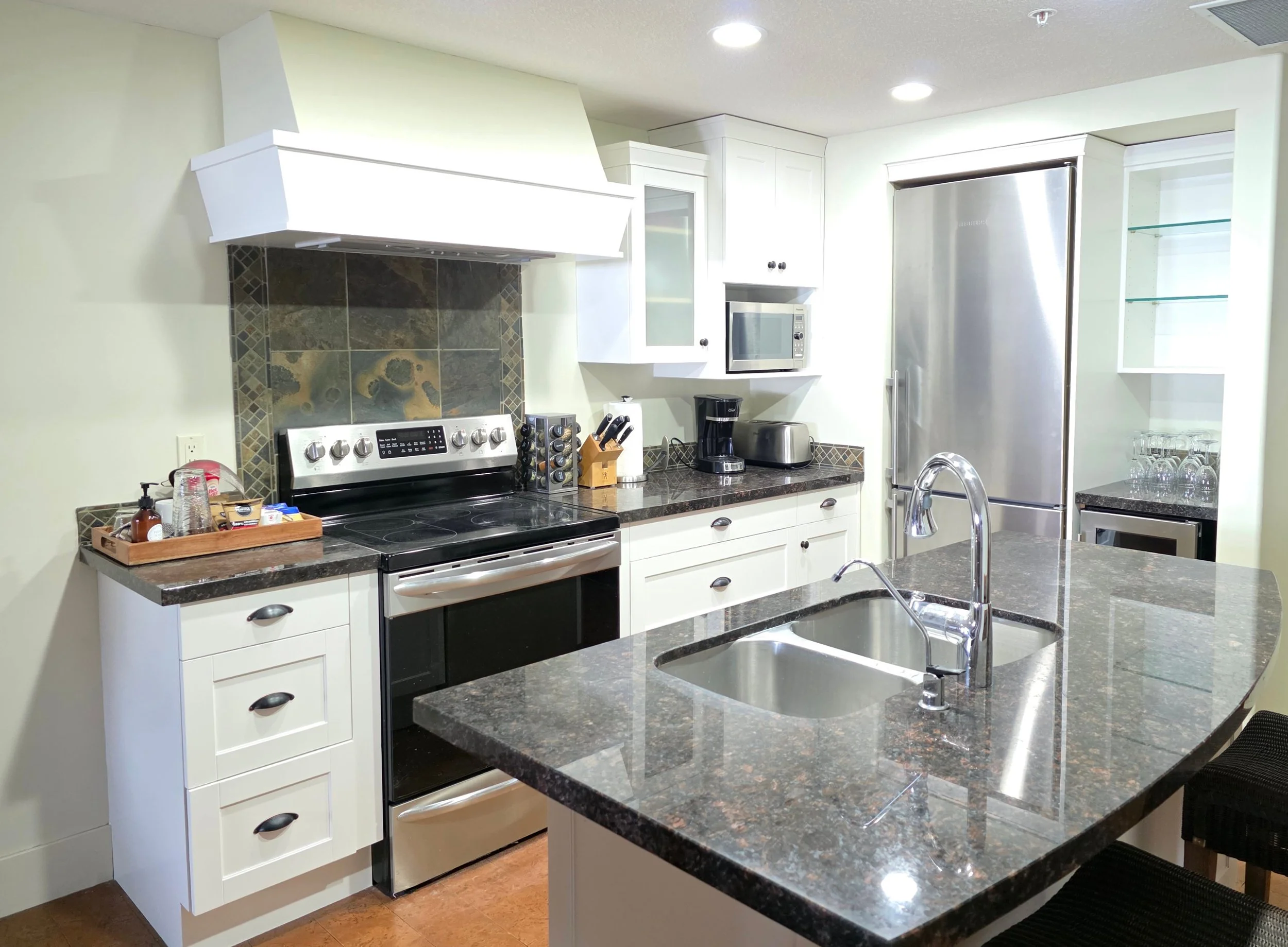 Full kitchen cabinet refinishing project at Solara Bow, Canmore, by Final Coat Painting Inc.