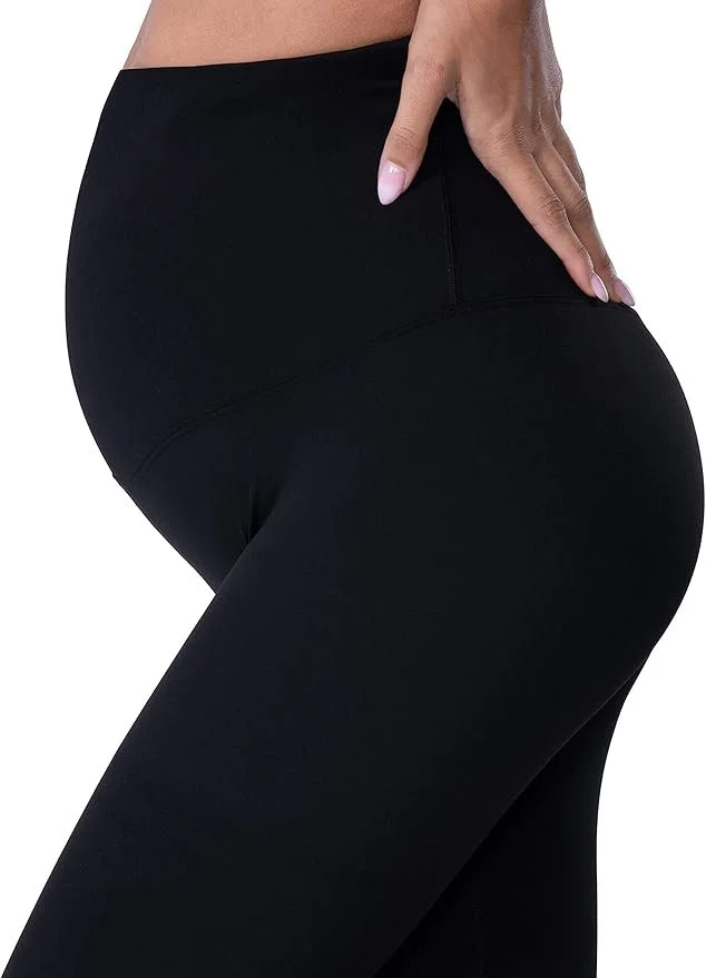 Close-up of a woman wearing black high-waisted leggings, with her hand resting on her hip.