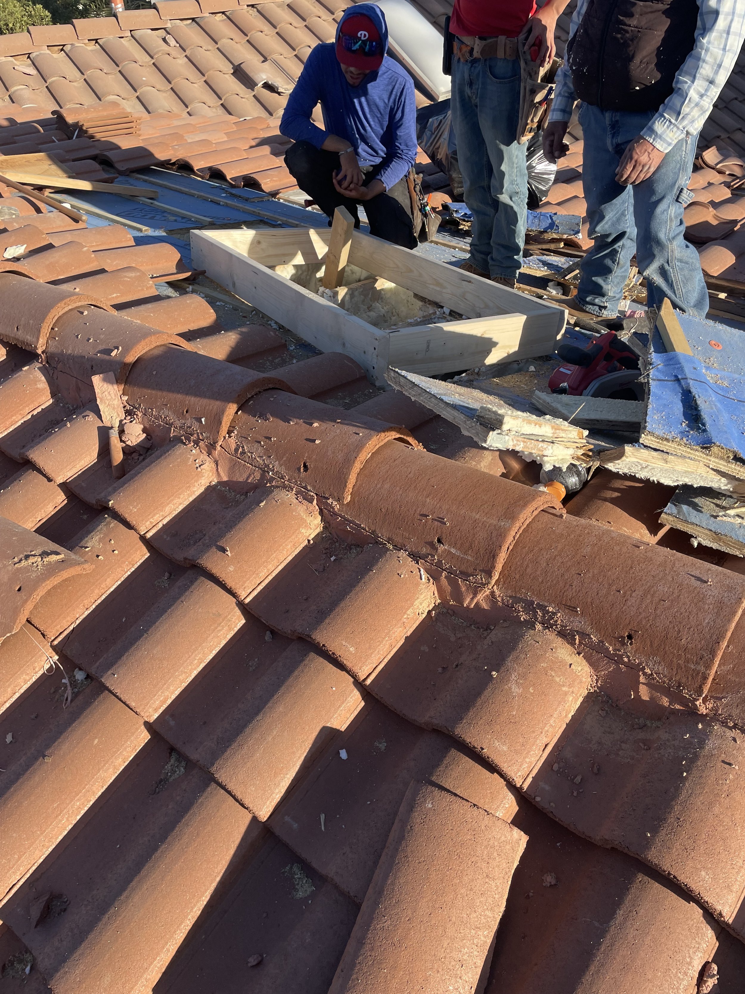 Construction workers repairing a clay tile roof