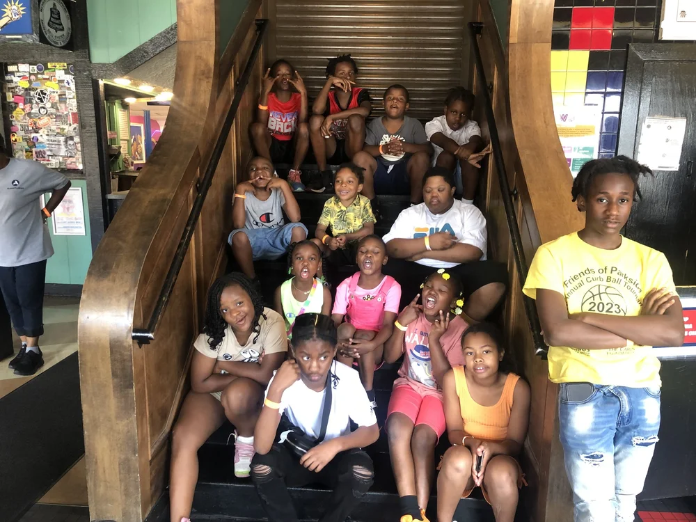 Young people gather on a staircase during a group outing.
