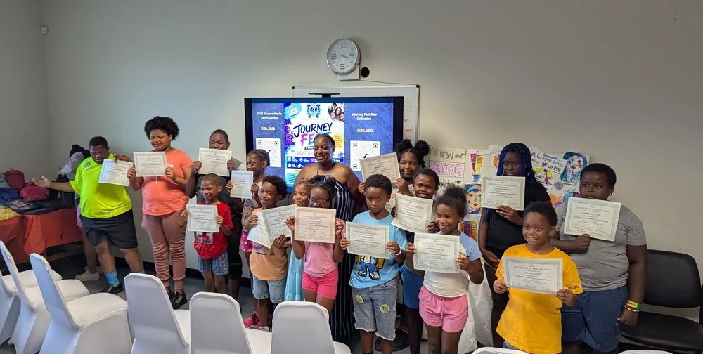 Youth participants hold certificates together at a program celebration.