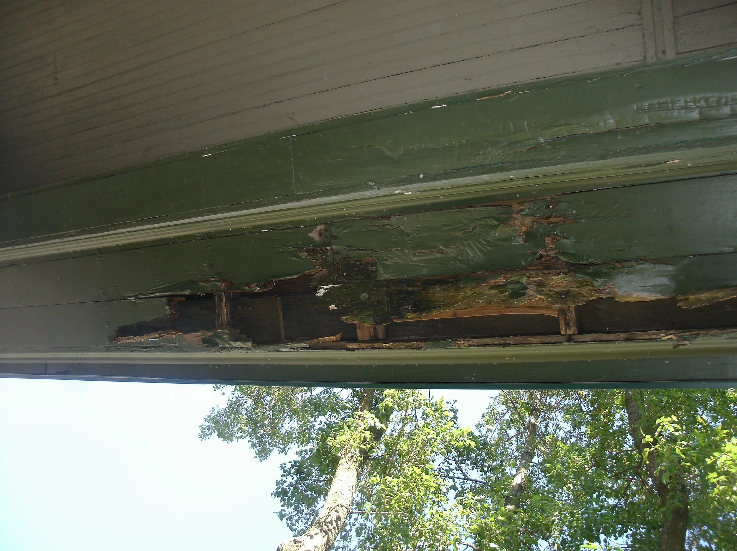 More extreme beam and soffit water damage on the front face of the porch.