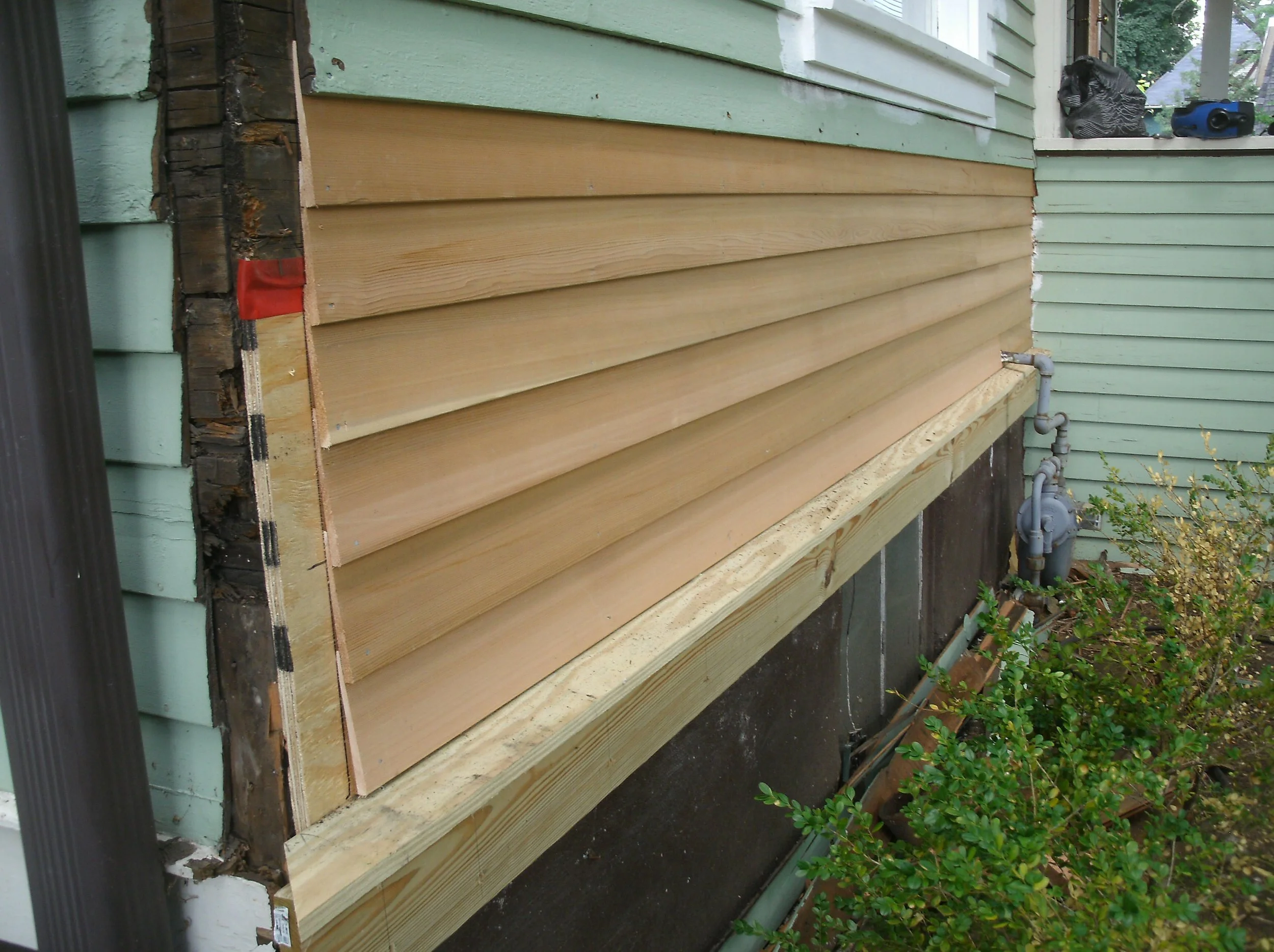 New cedar siding replacing damaged, original siding