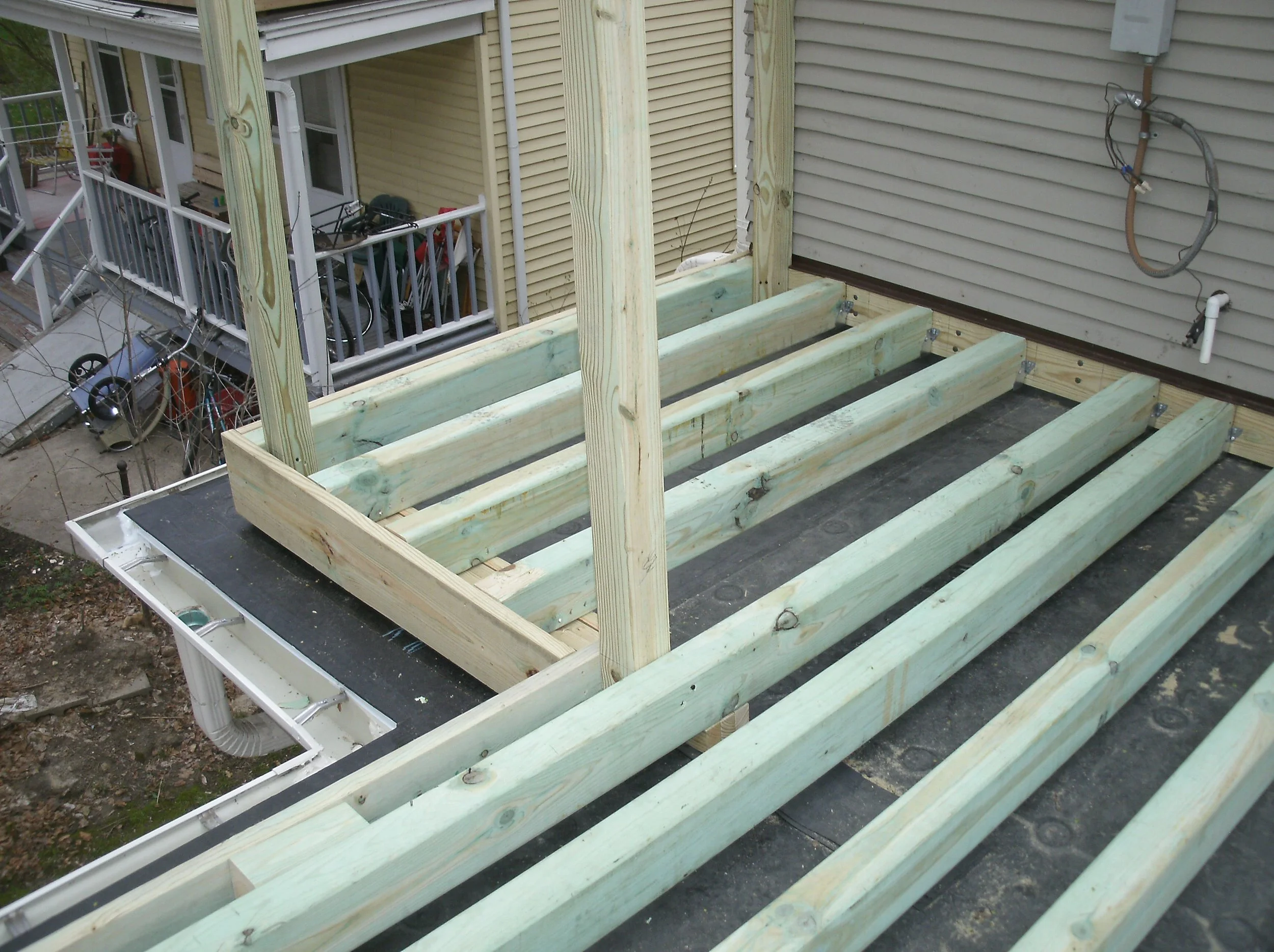 Handrail posts installed. The roof below had a pitch to shed water. Deck was level.