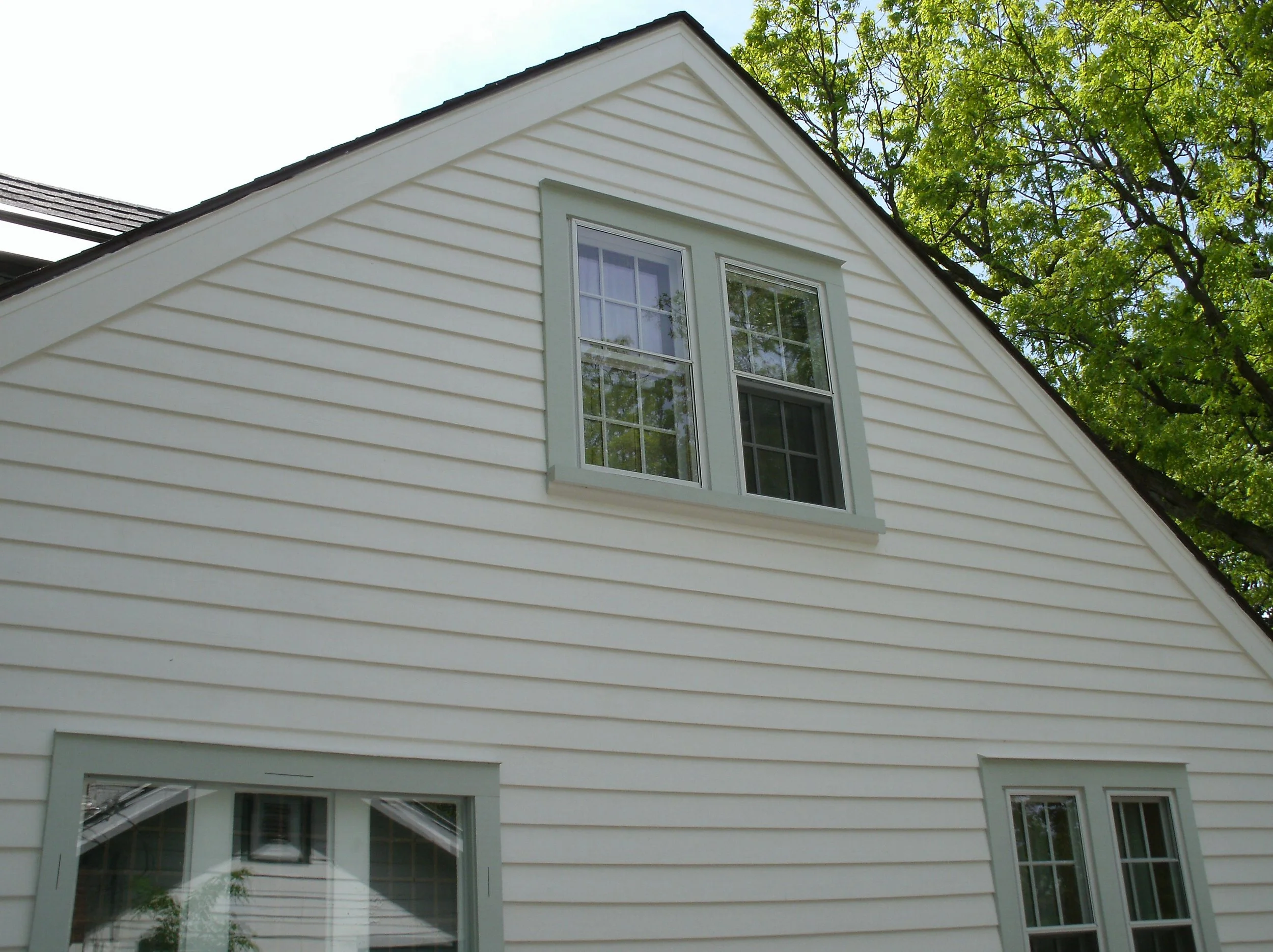 Another view with new cedar siding, new windows and trim painted.