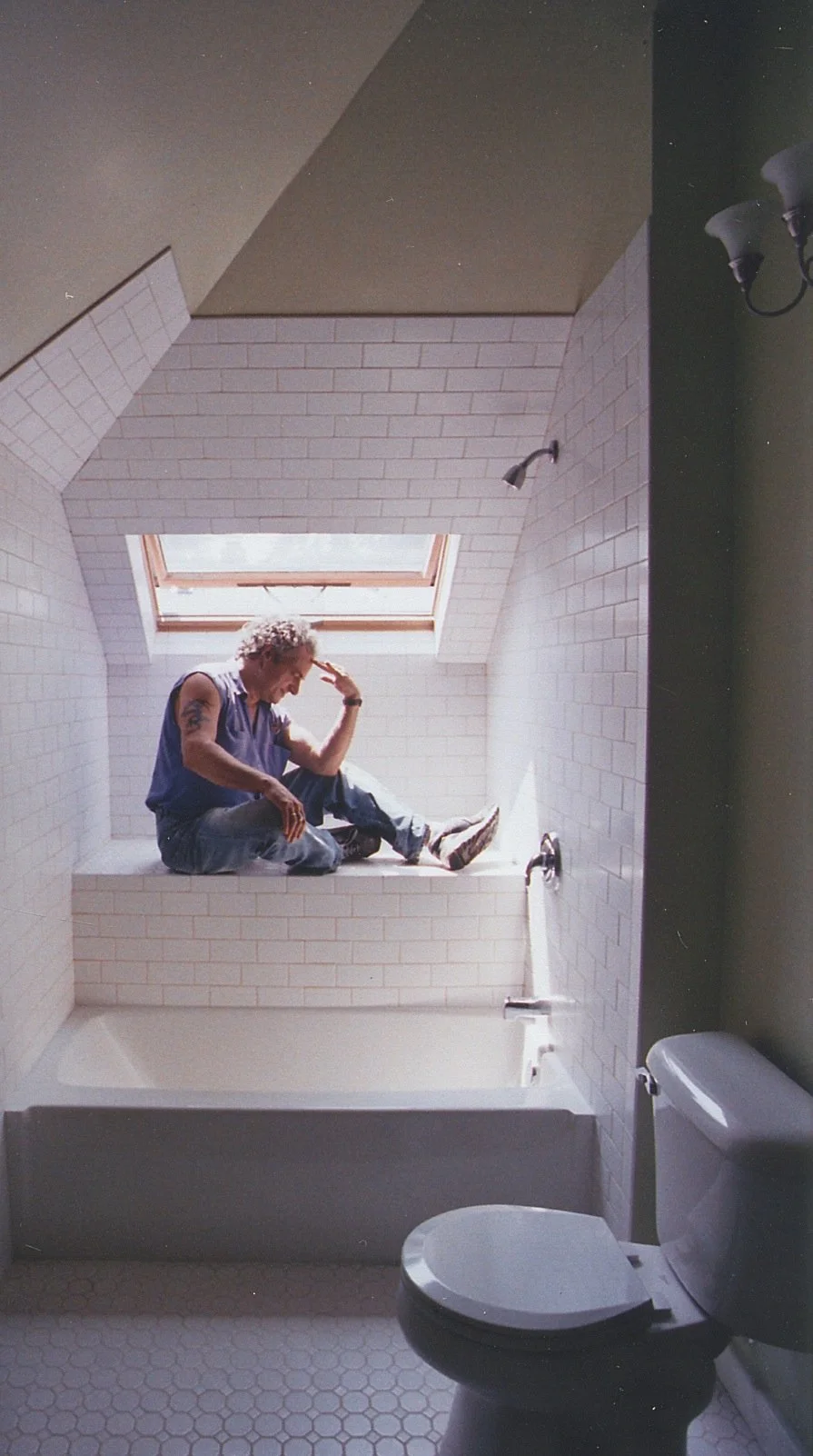 Welcome into the bathroom nestled under the roof. Chimney is exposed on right. 