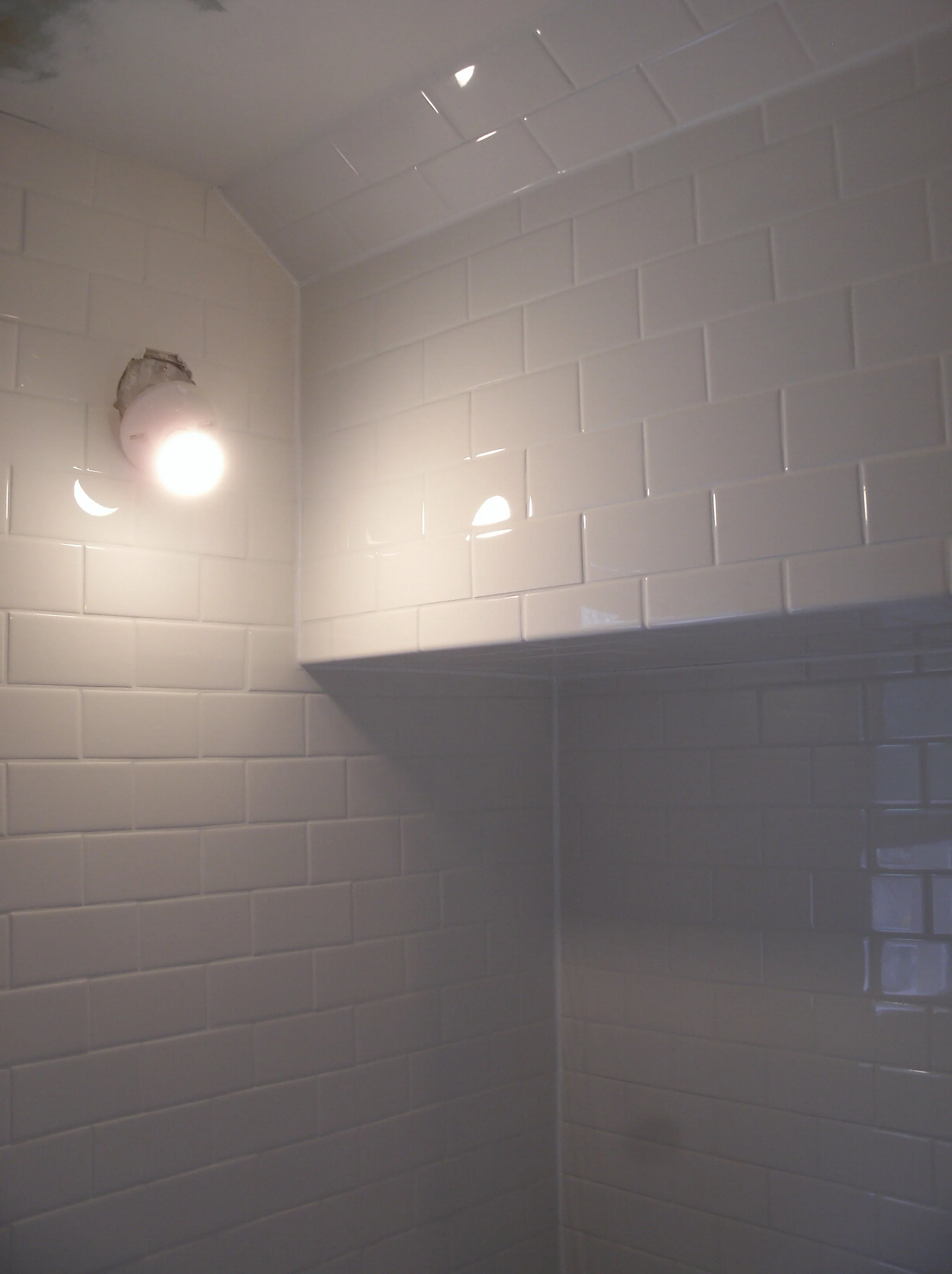 A second view of the toilet alcove and the wall tile