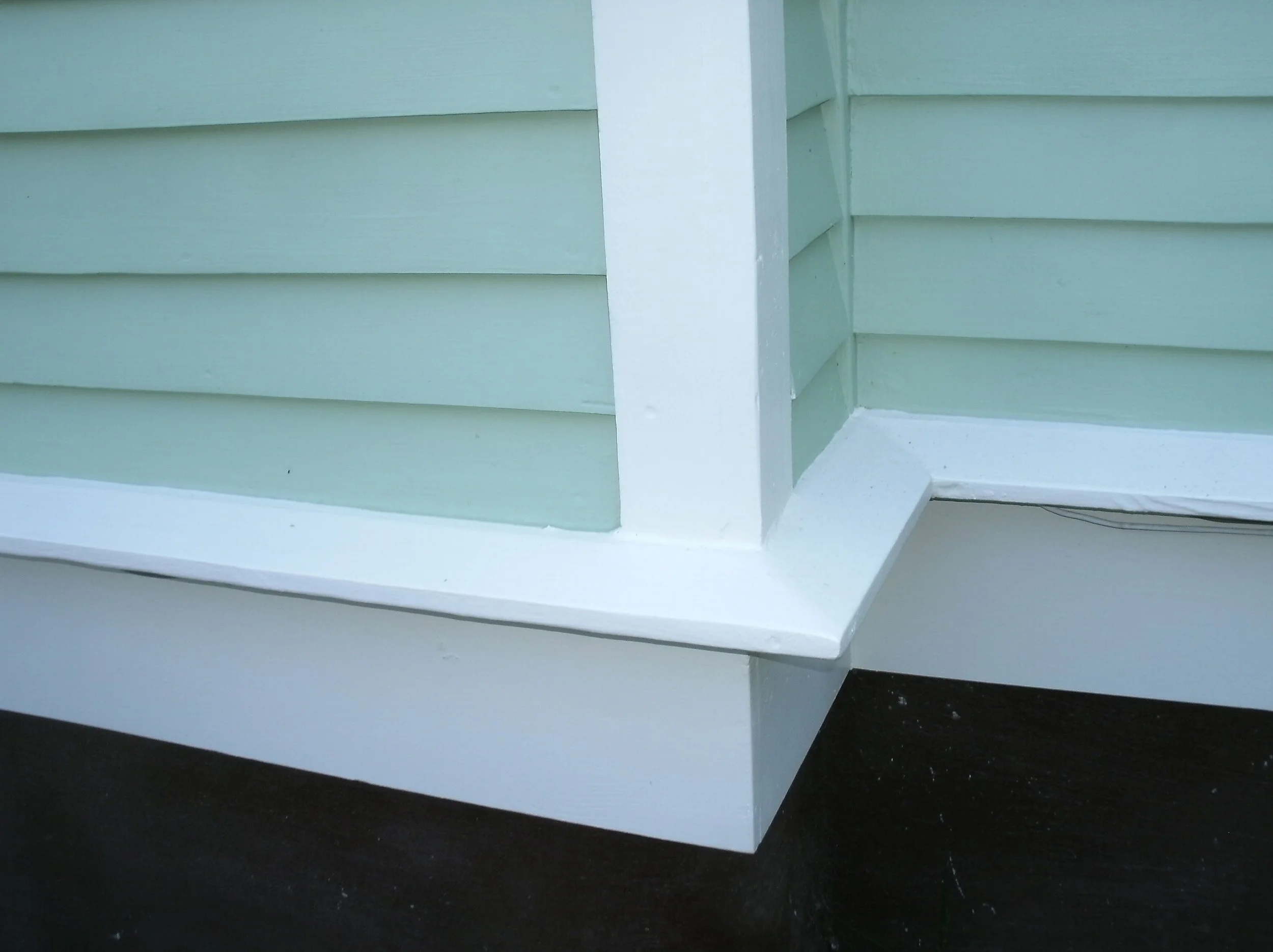 Detail of the corner with all new wood, primed and painted.