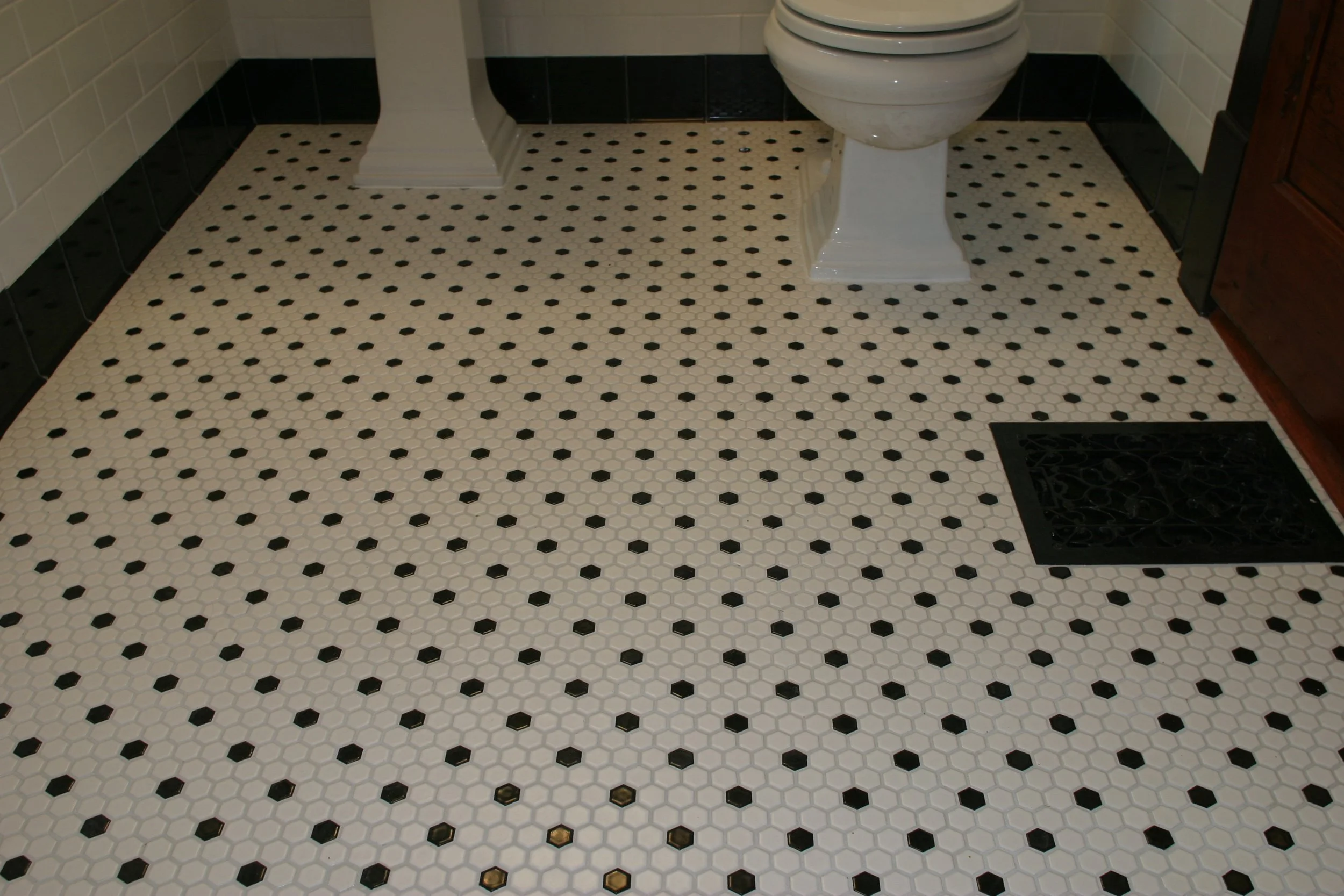 This is a view of the tiled floor and the black tiled baseboard.