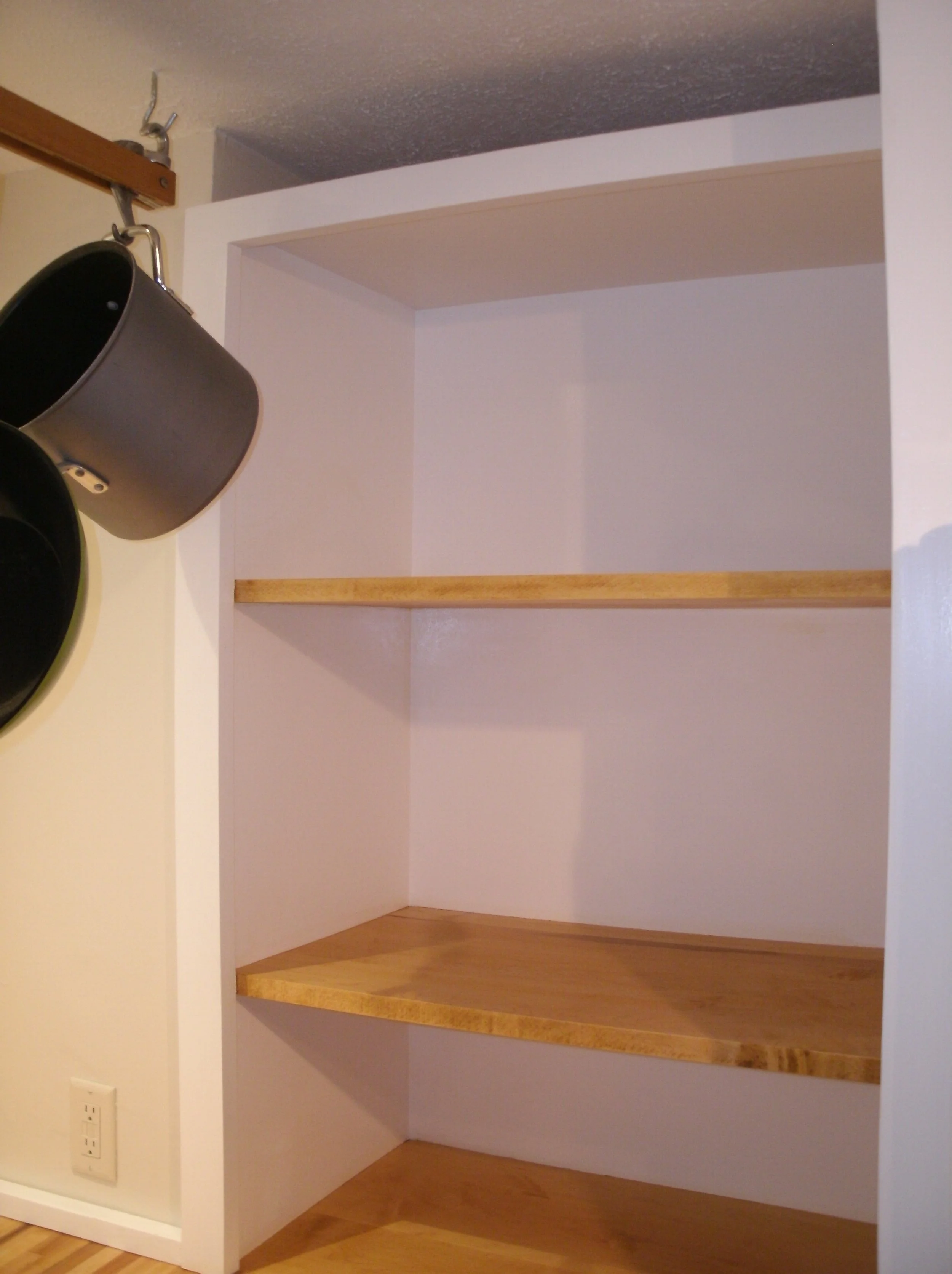 Shelves between sink countertop and refrigerator enclosure box