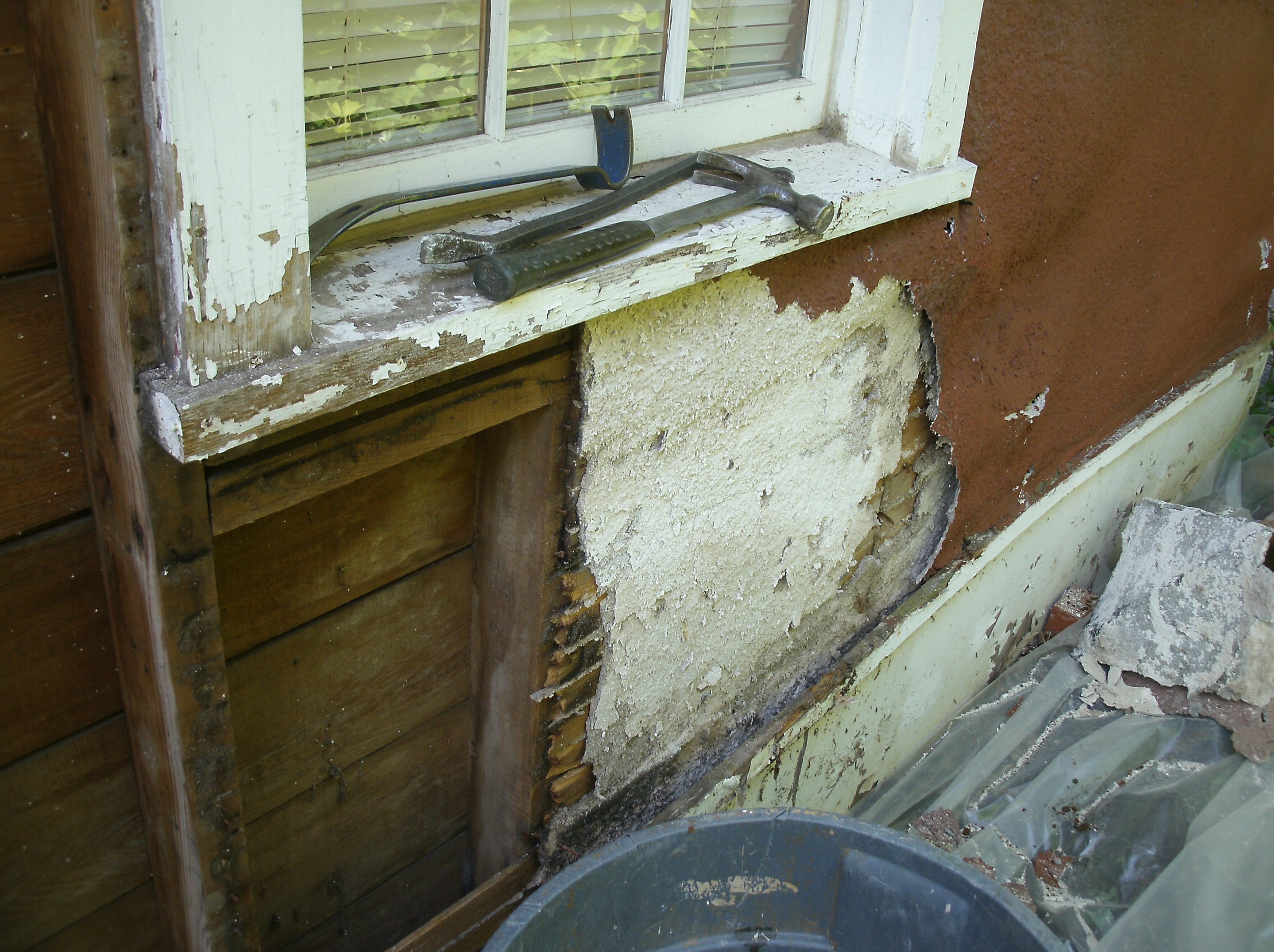 More mid demolition with a view of the rotted stuccoing and bottom trim