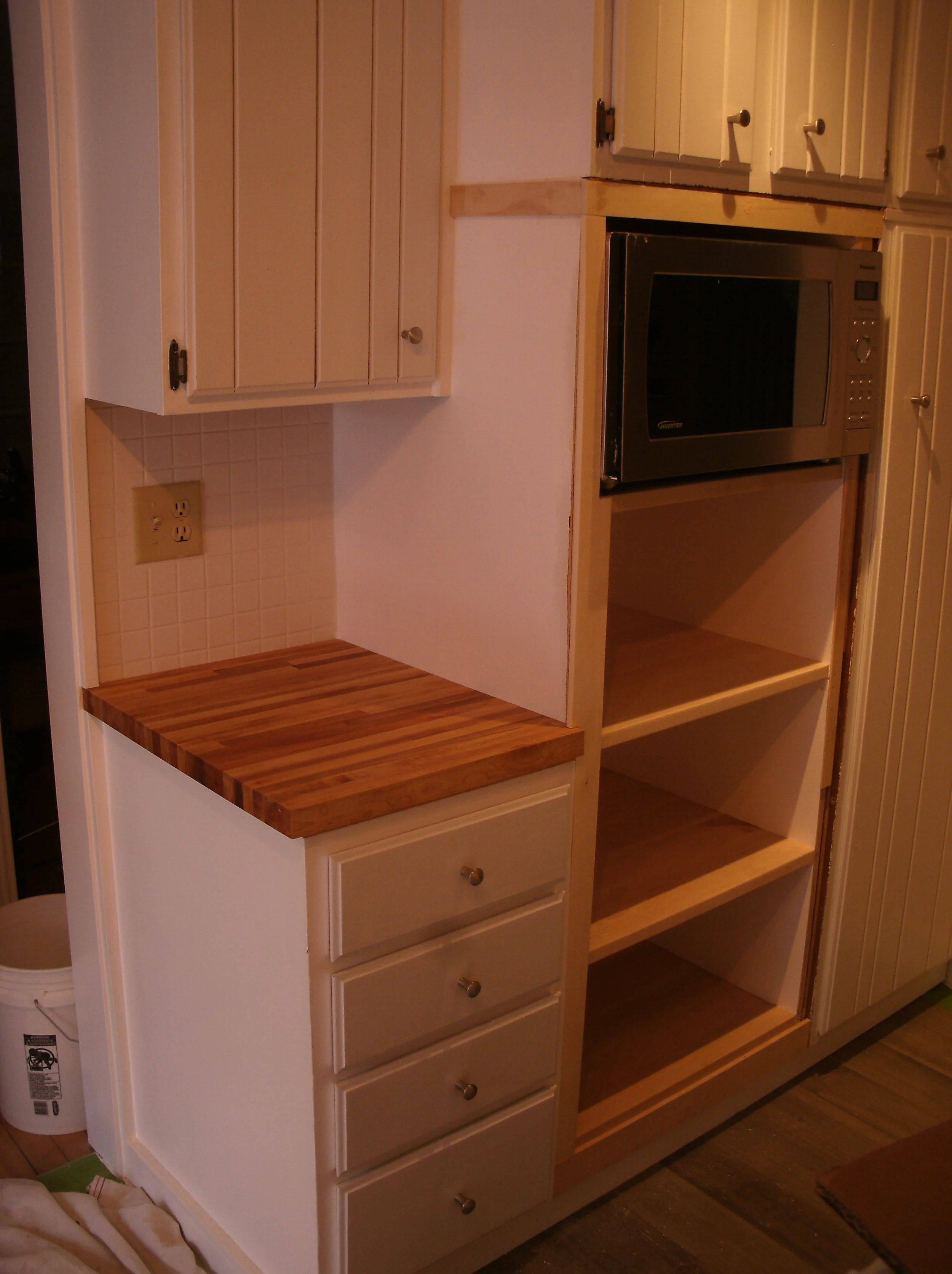 A view of three butcher block shelves and a small countertop