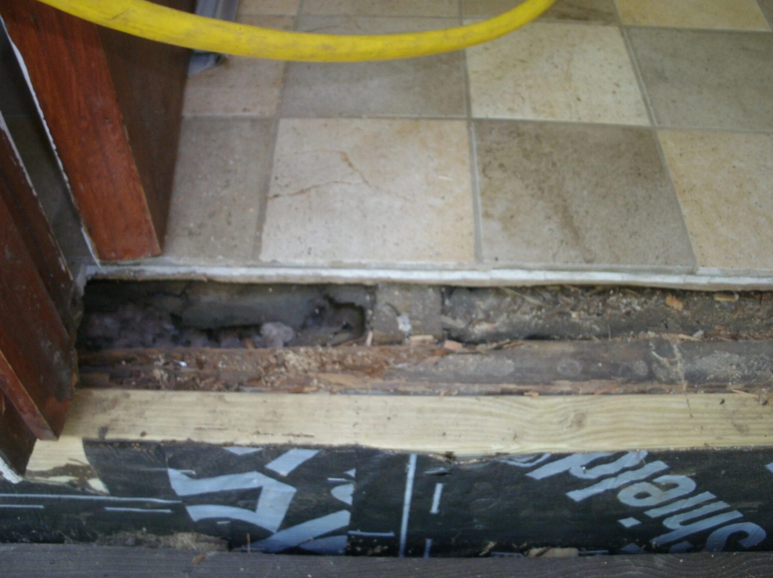 View of the rotted wood under the rear entry mudroom.