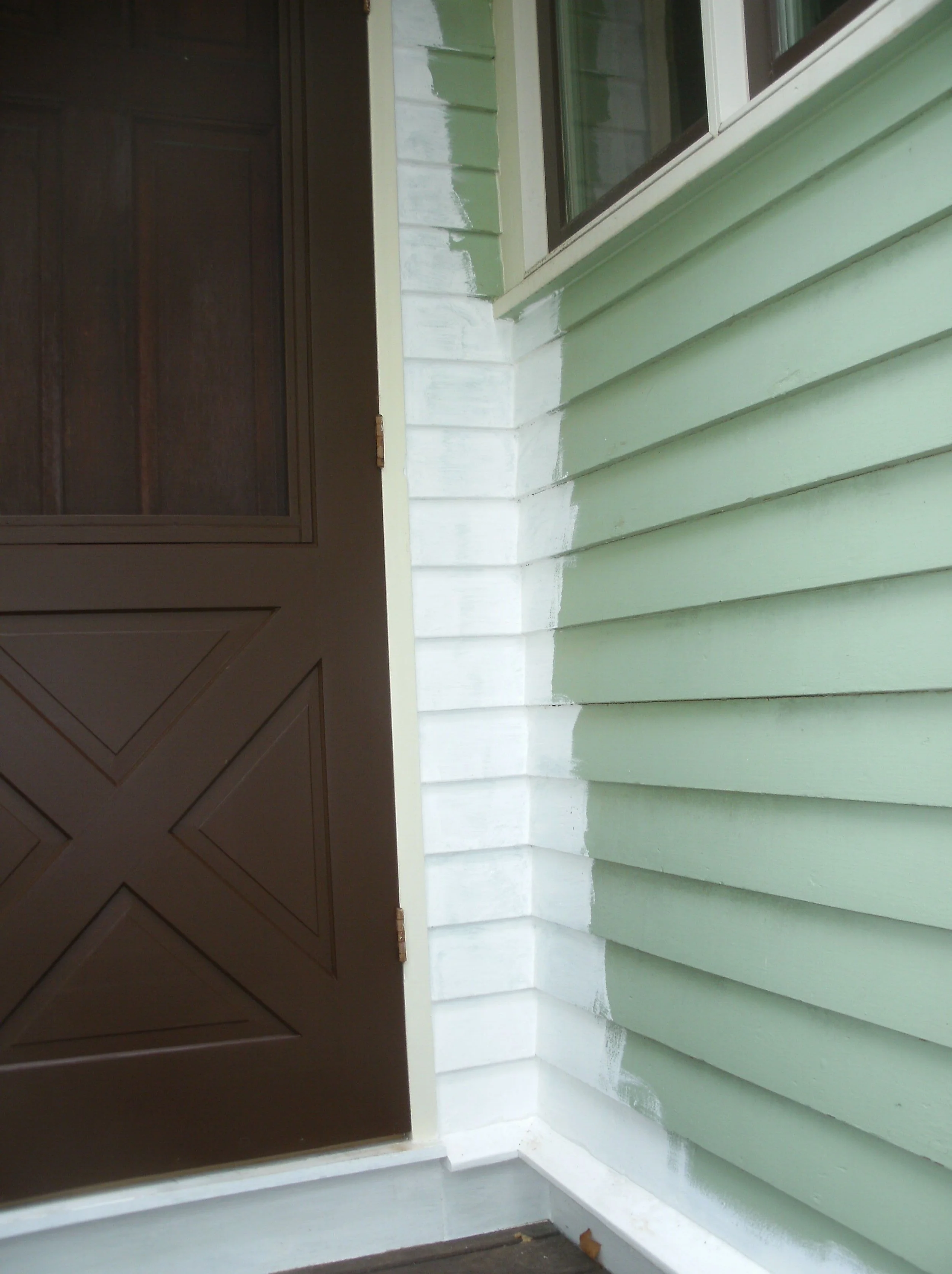 Detail of the right side of the trim and siding next to the storm door