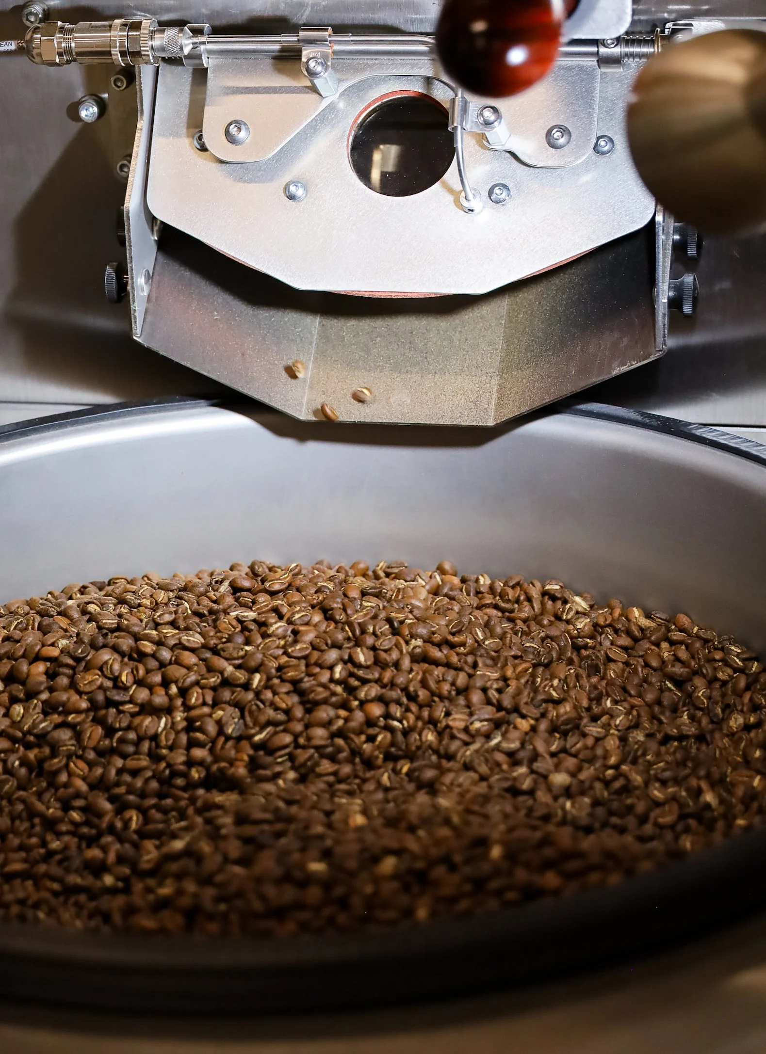 Roasting machine with coffee beans cooling in a pan