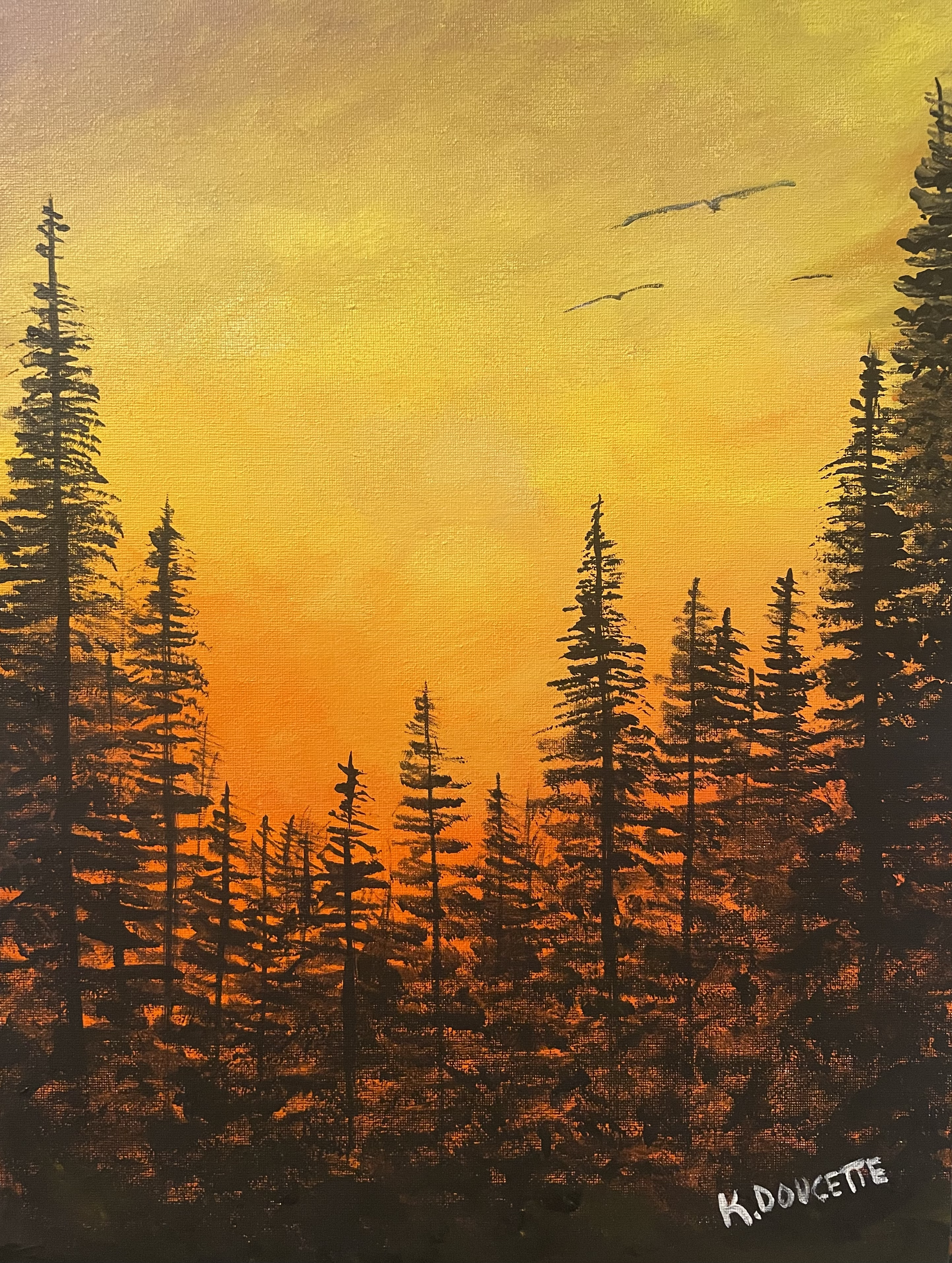 Silhouette of pine trees against a vibrant orange and yellow sunset sky, with birds flying overhead.