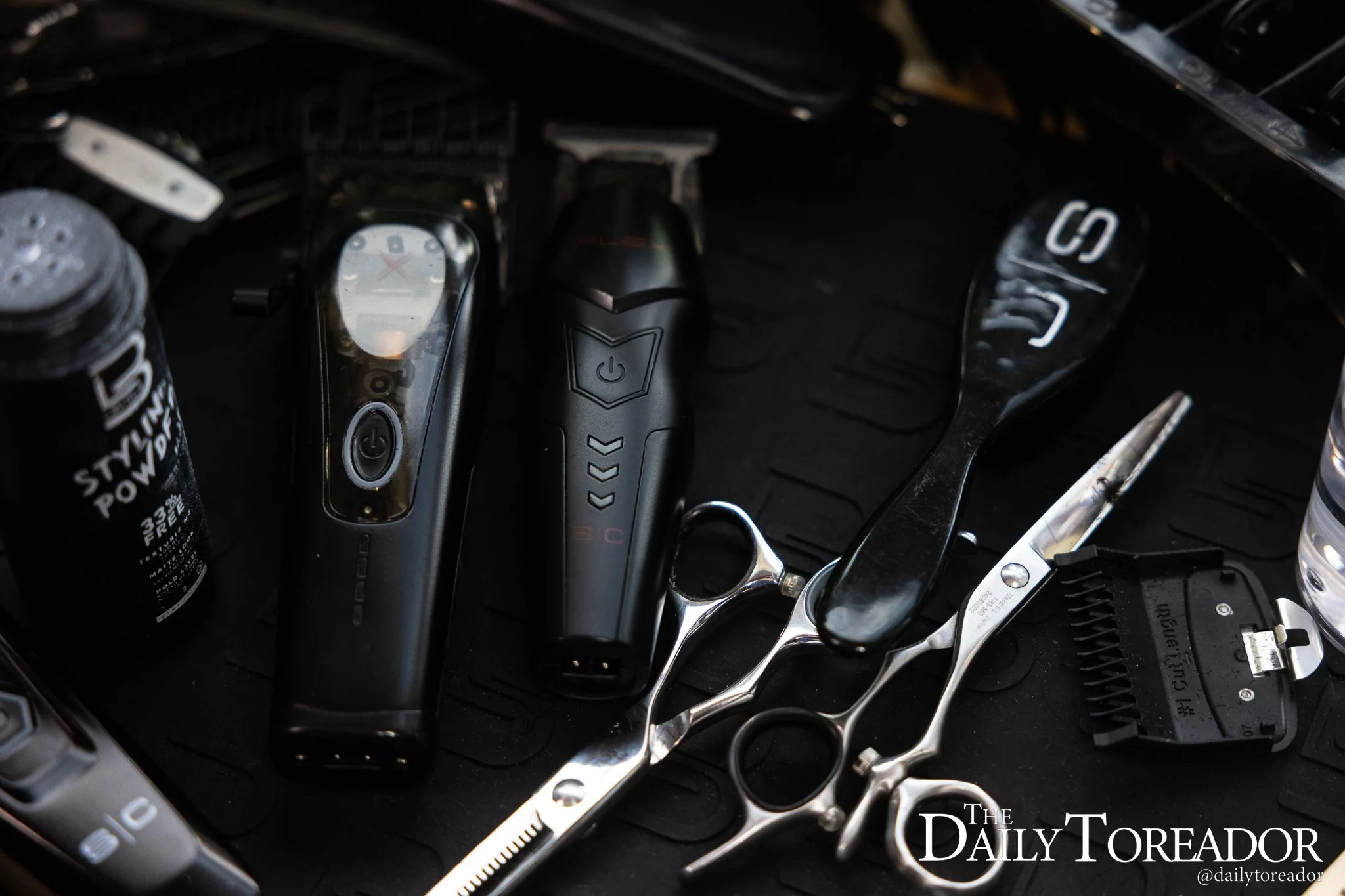 A collection of scissors, clippers and products sit on the shelf near Aguirre’s desk inside his dorm.