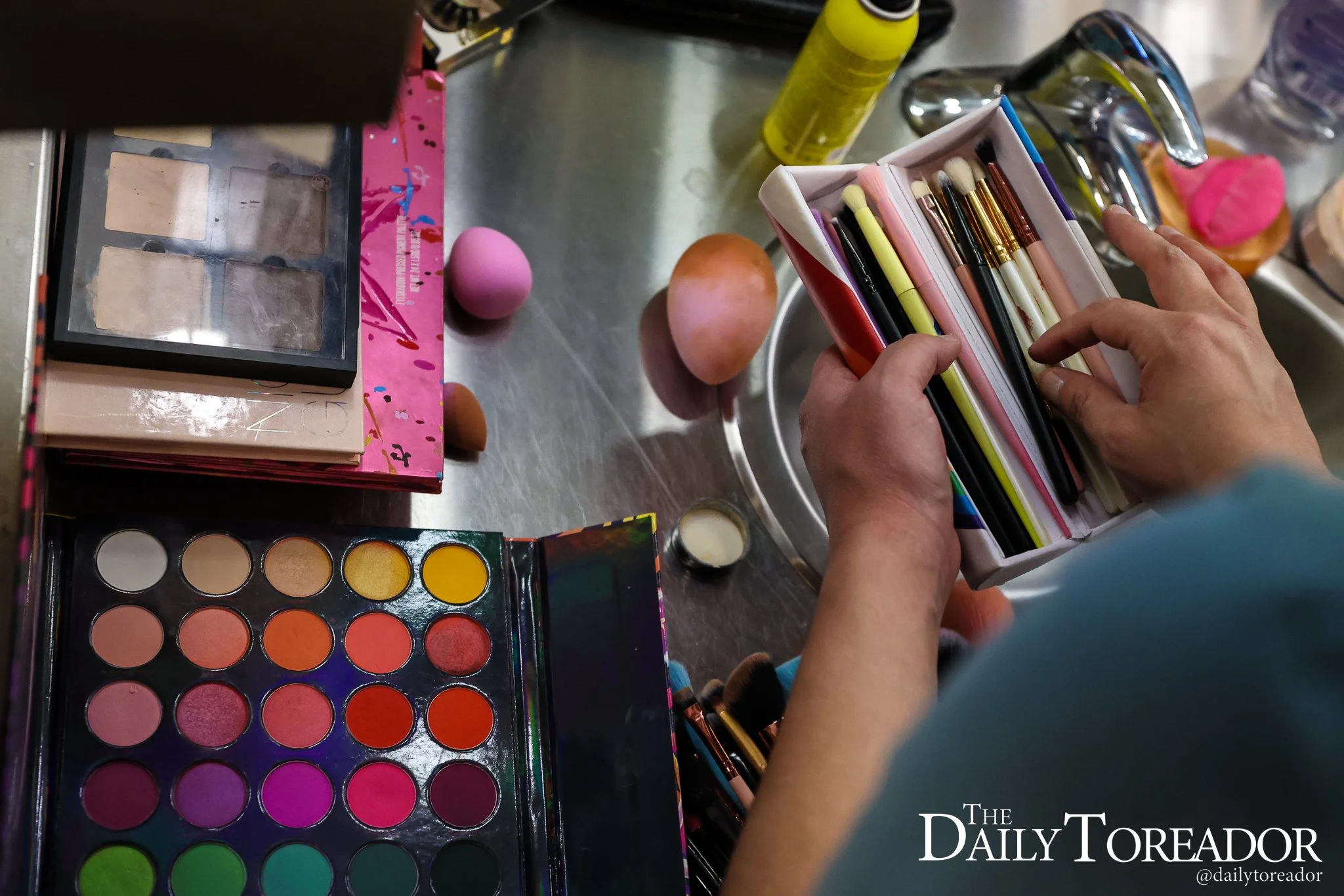 Malaysia, a Lubbock drag queen, combs through an assortment of makeup brushes while getting ready for their performance at Lubbock PRIDE's Pride Fest at the Louise Hopkins Underwood Center for the Arts in downtown Lubbock, June 28, 2025.