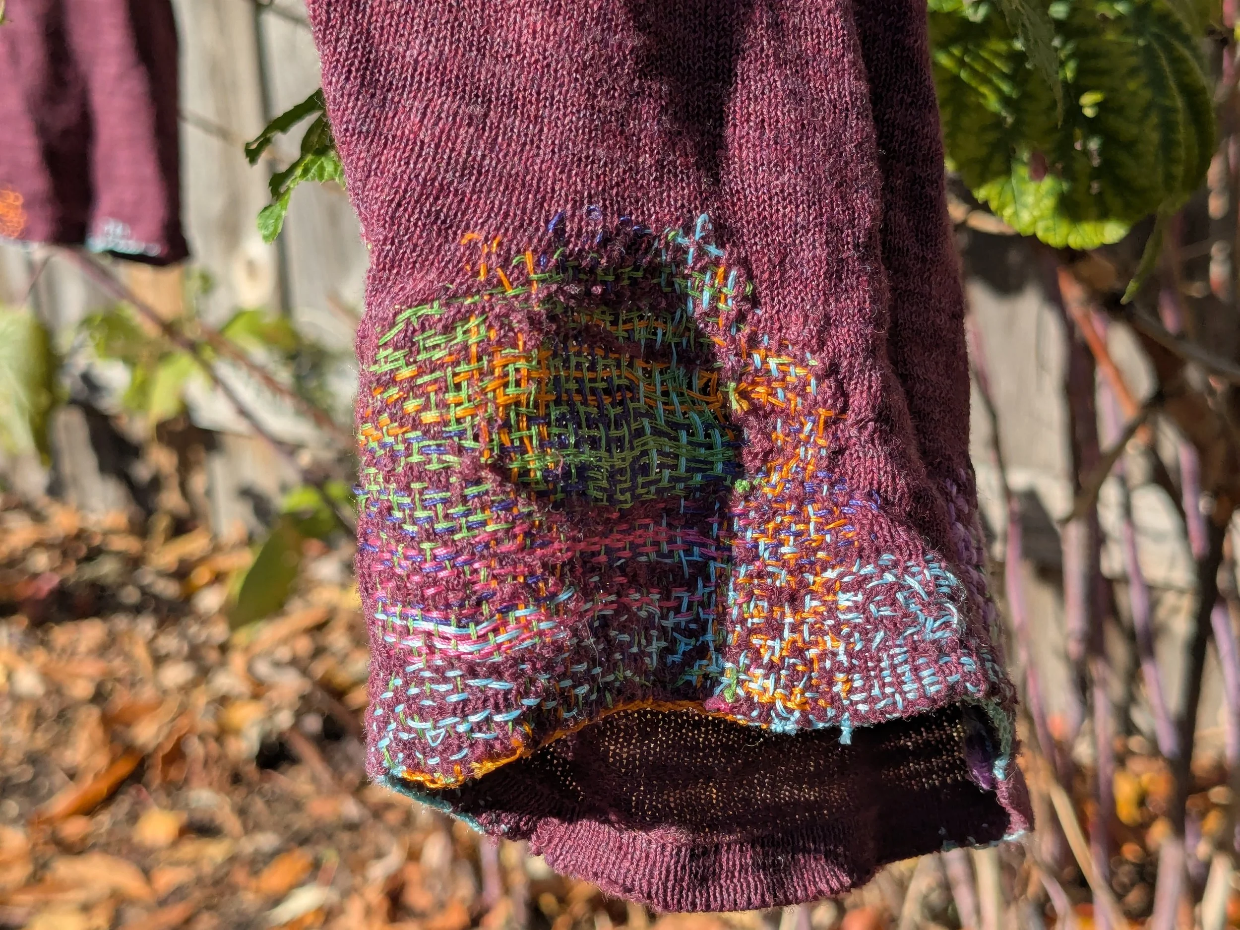 Visible mending and repair with needle weaving.